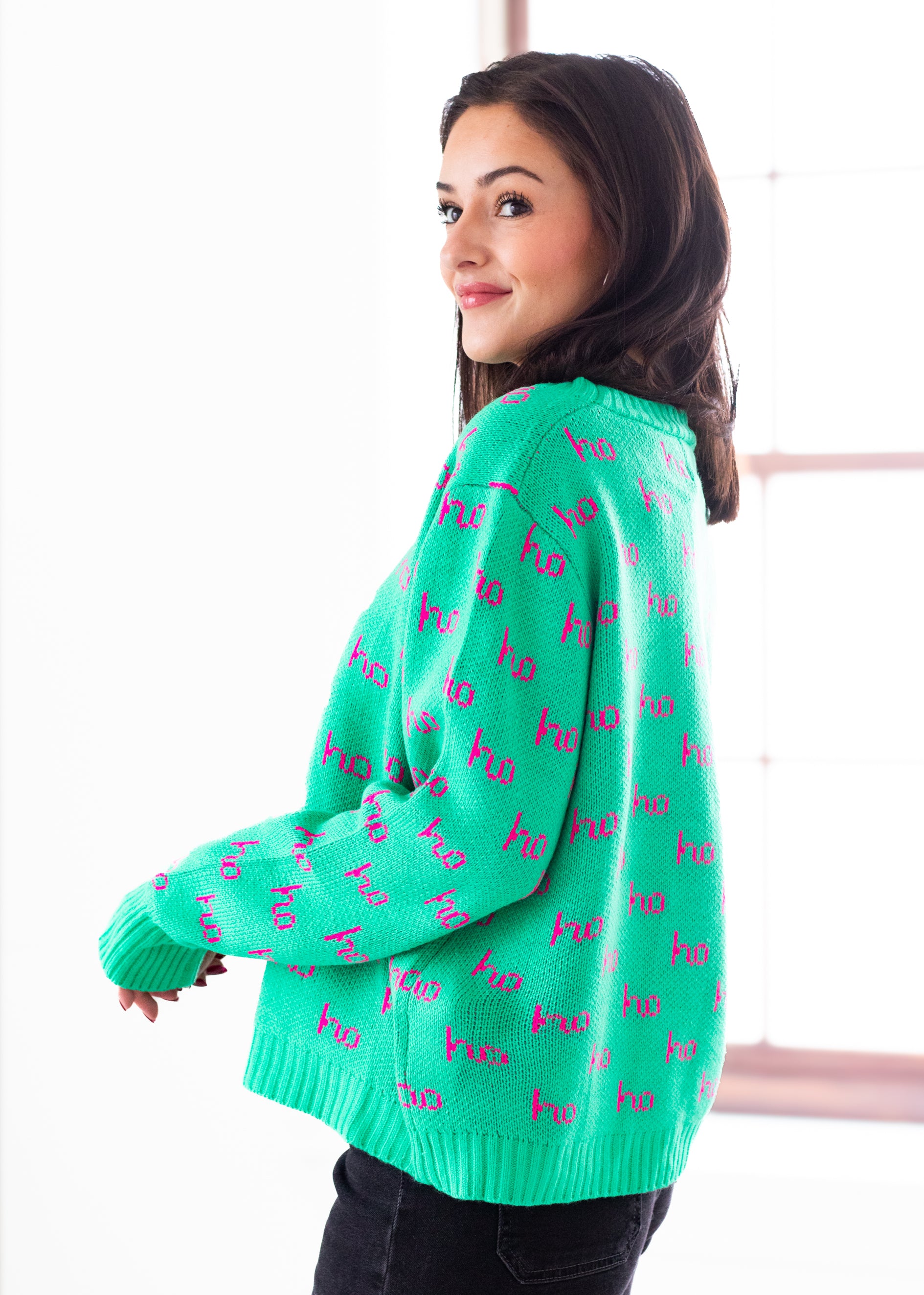Woman wearing a green sweater with text pattern on a white background