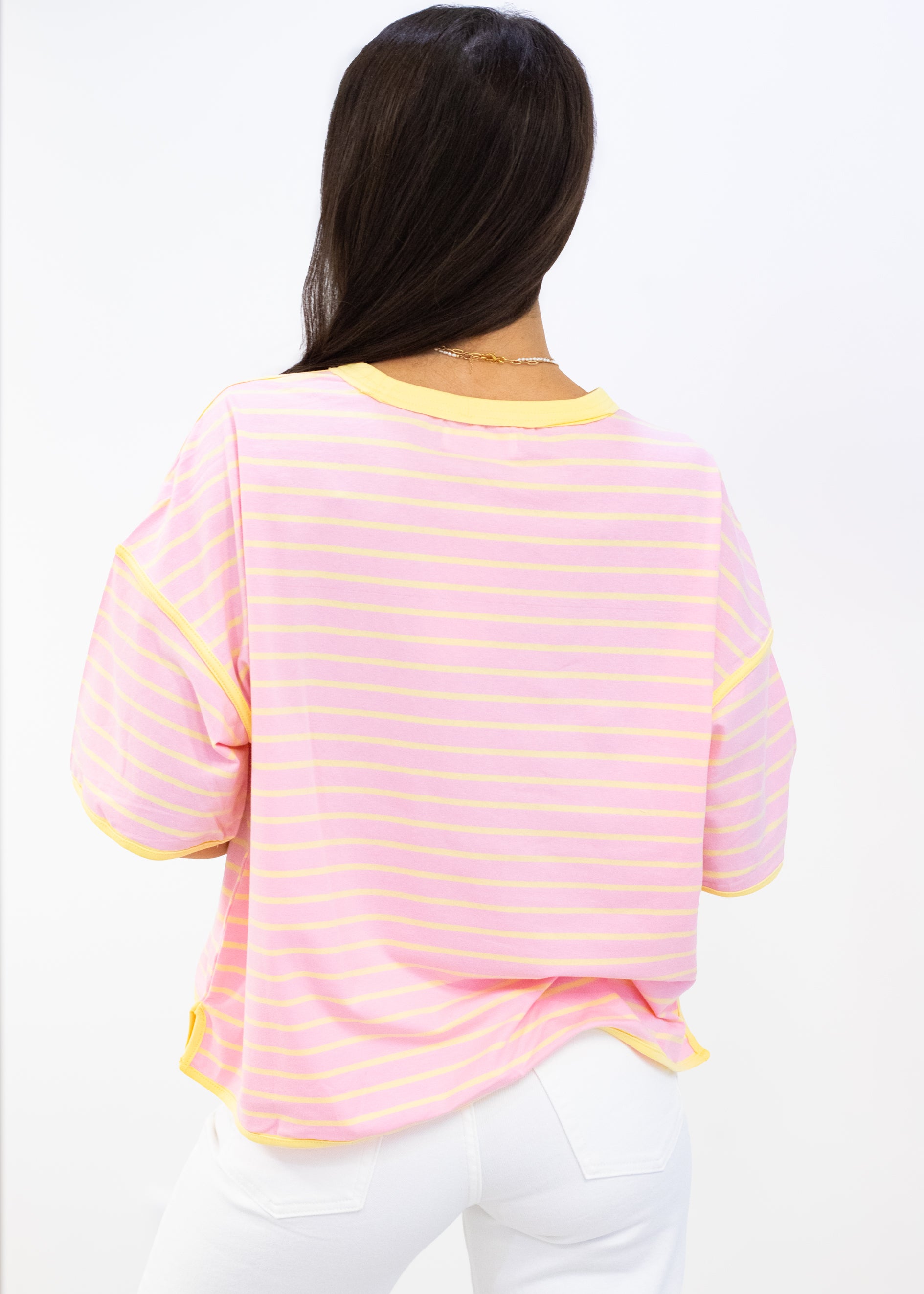 Person wearing a pink and yellow striped shirt on a white background