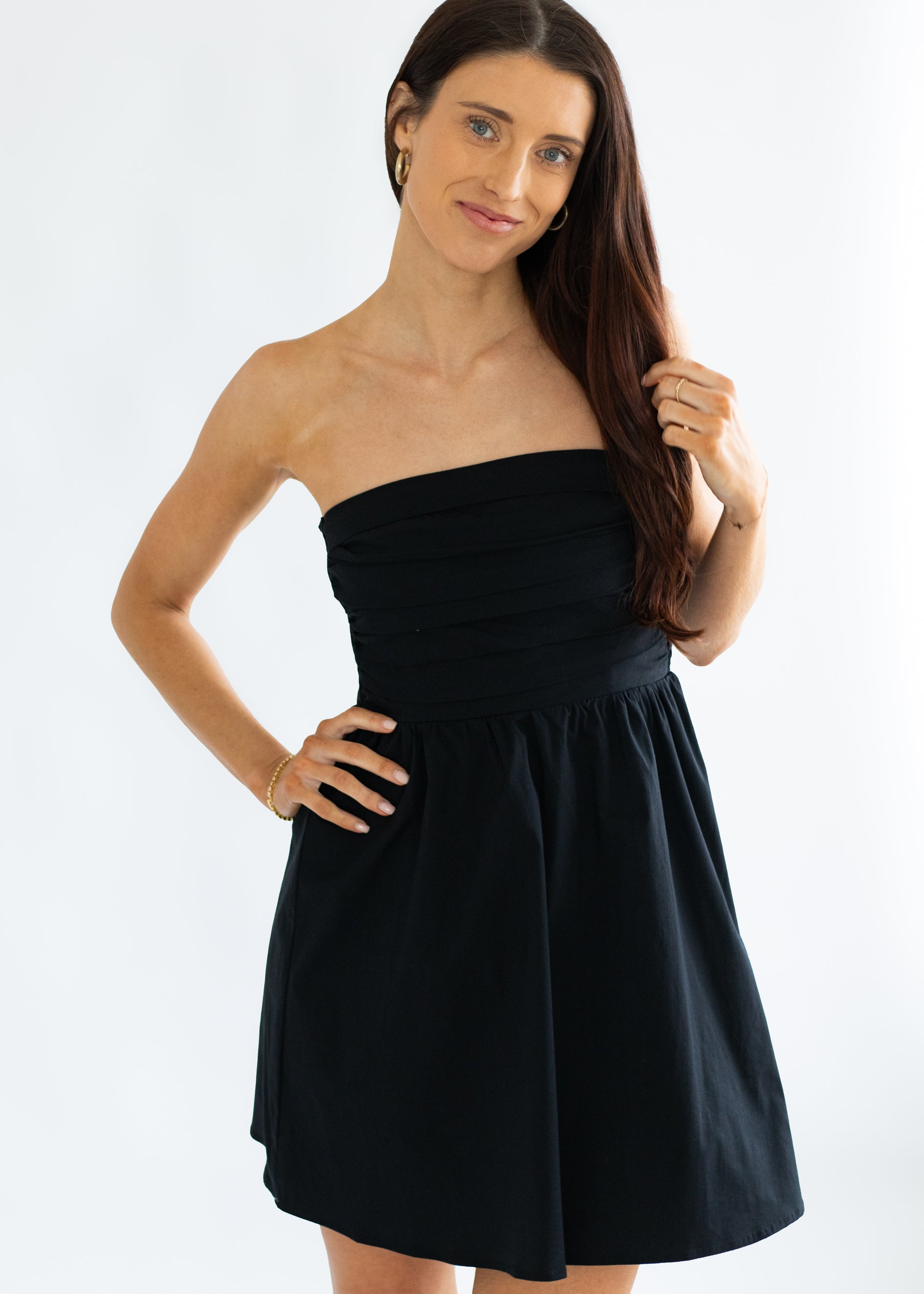Woman wearing a black strapless dress on a white background