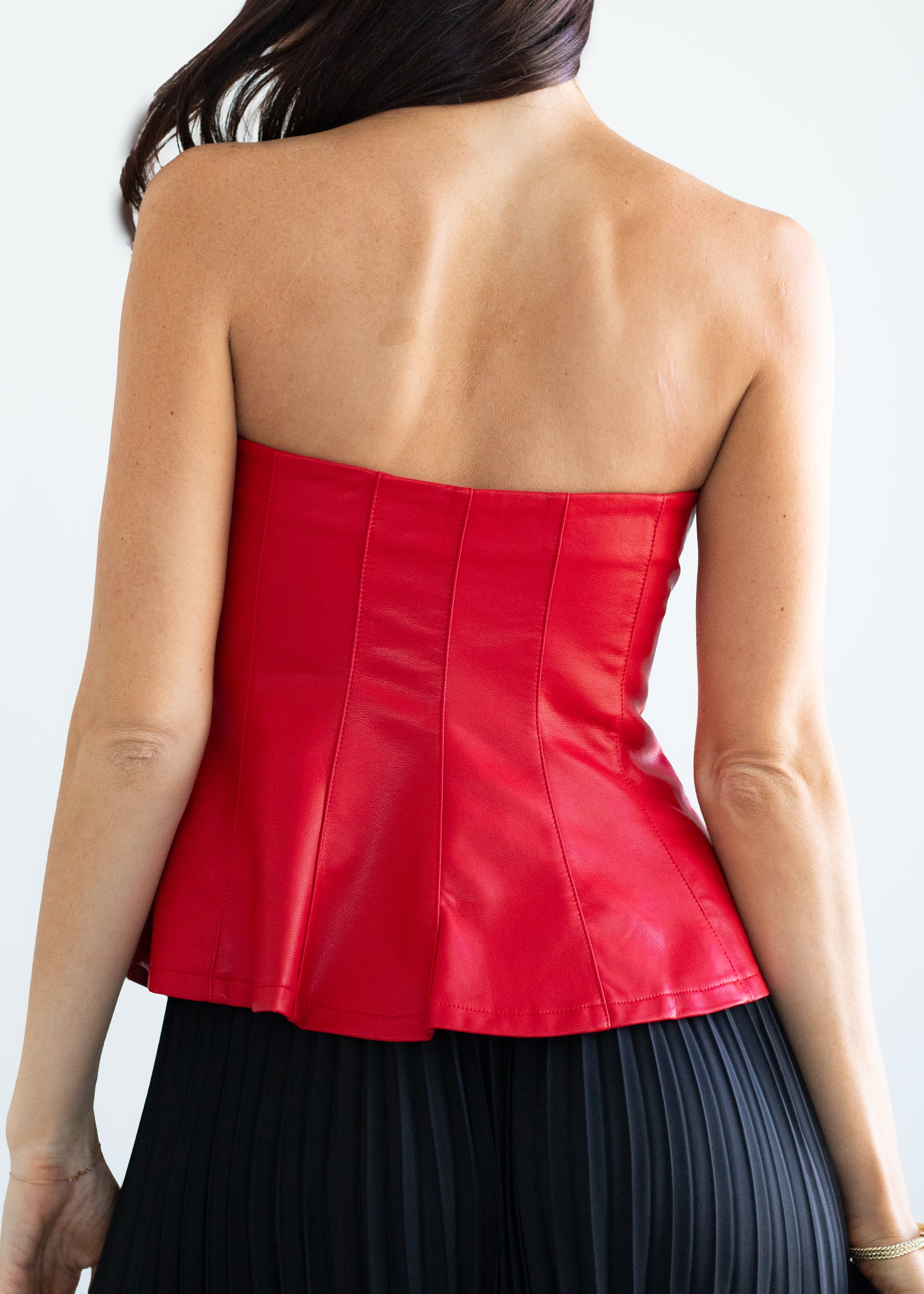 Red strapless top worn by a person on a white background