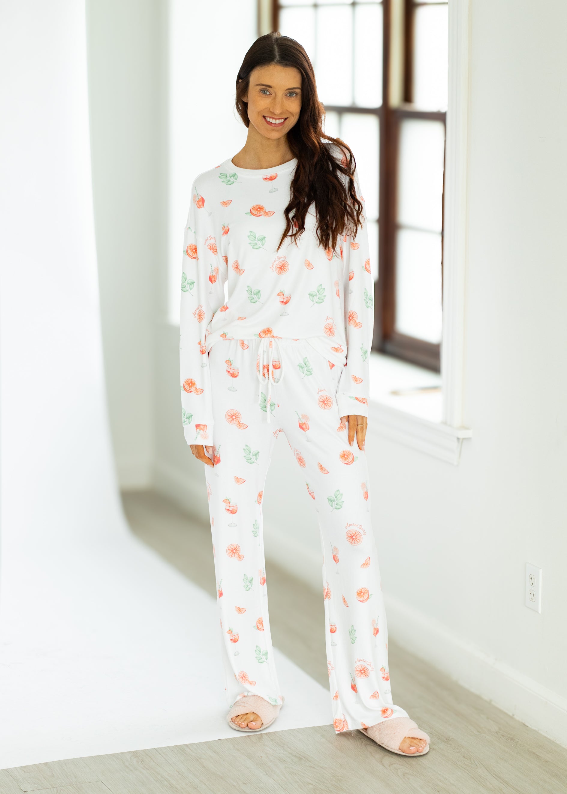 Woman wearing a floral pajama set in a bright room.