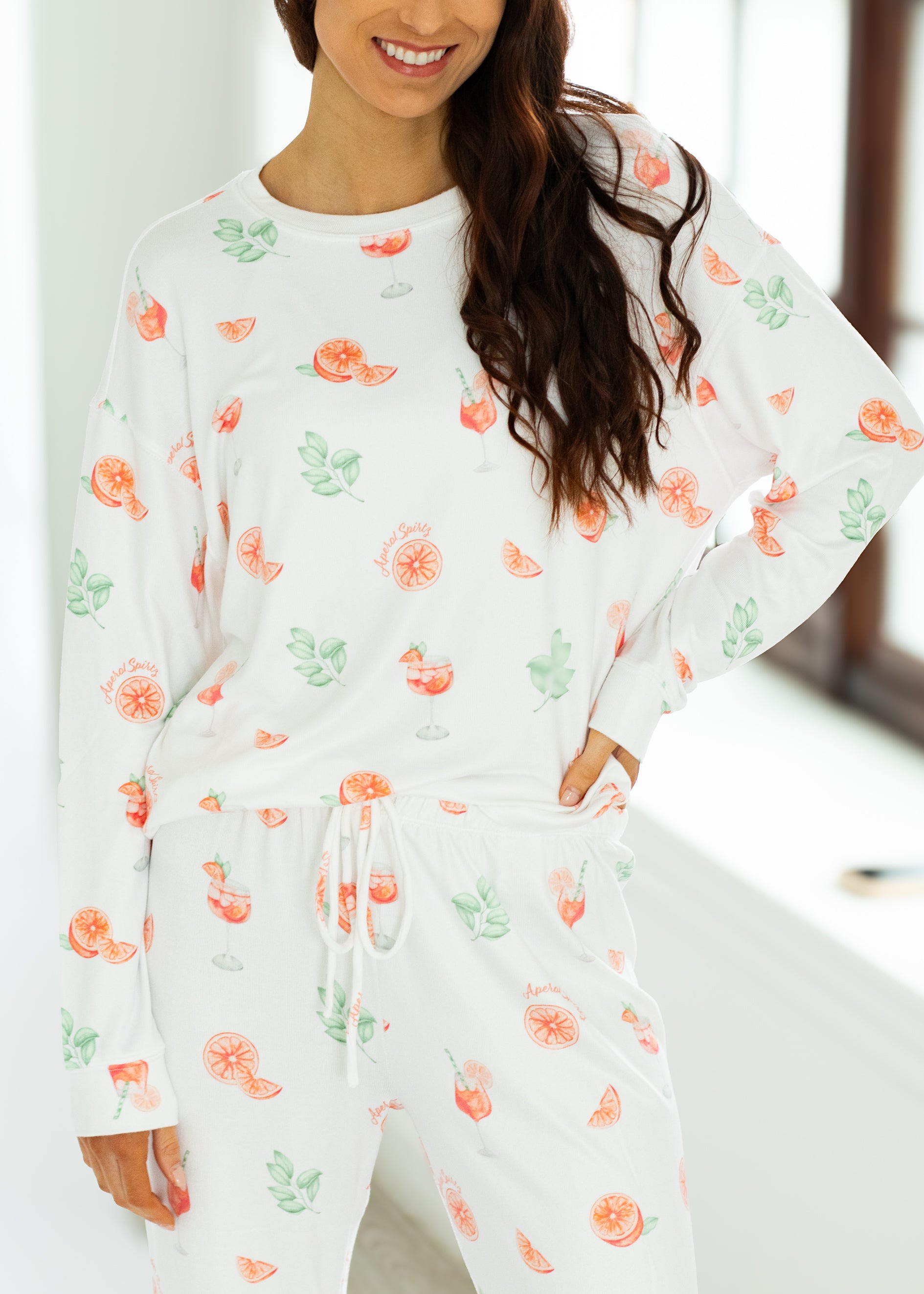 Woman wearing a white outfit with floral patterns in a bright room.