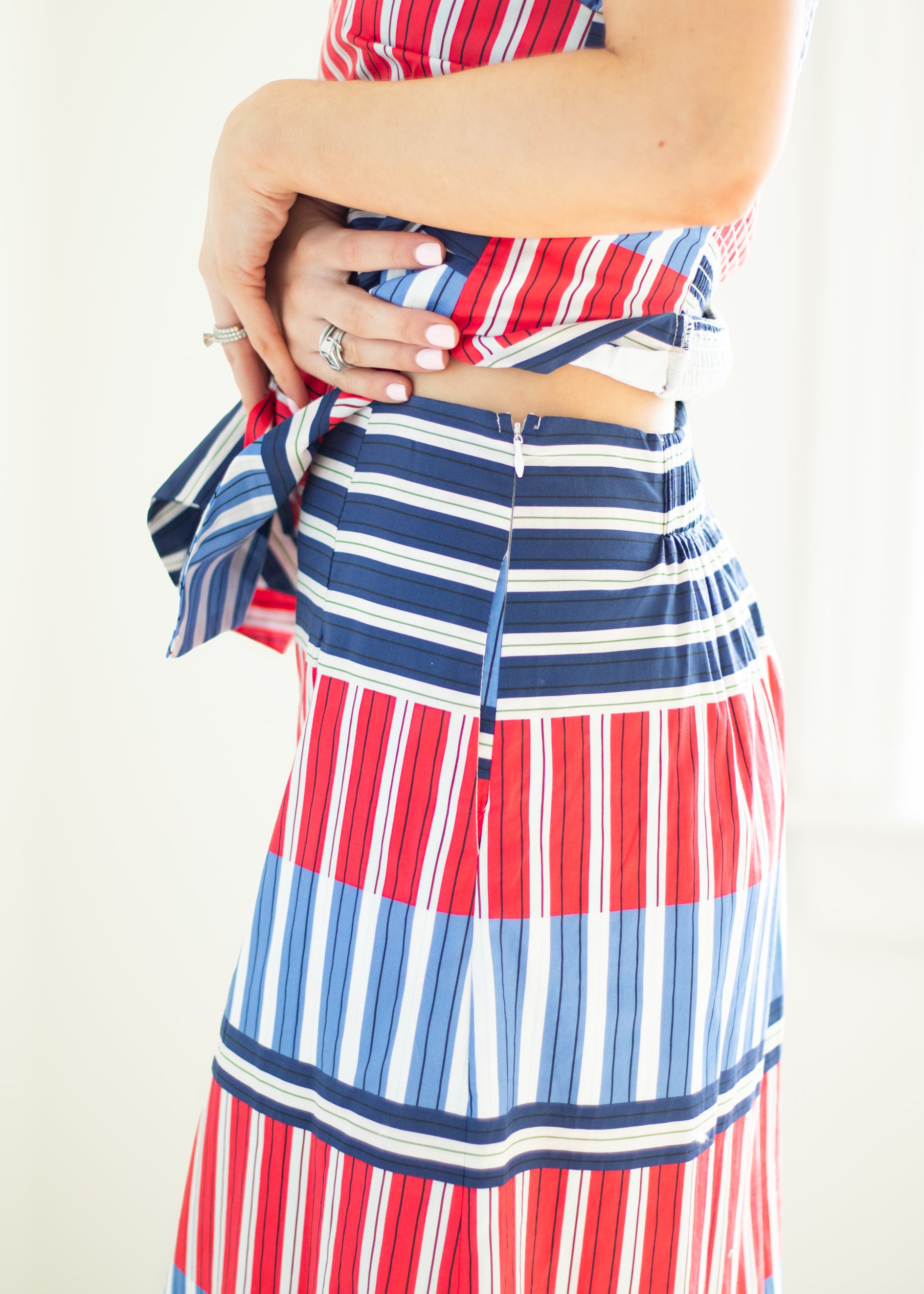 Person wearing a red, white, and blue striped dress with a white background