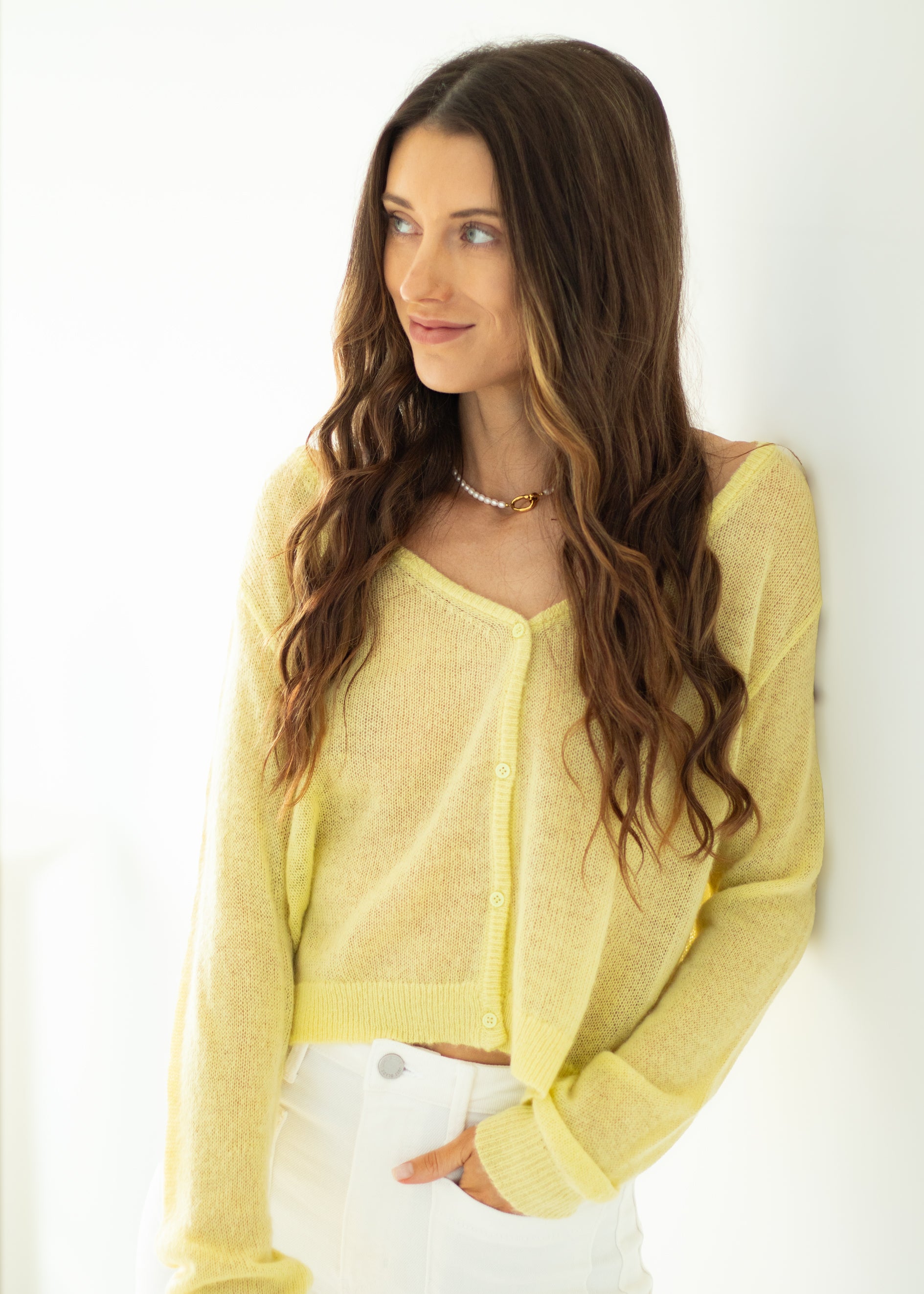 Woman wearing a yellow sweater against a white background