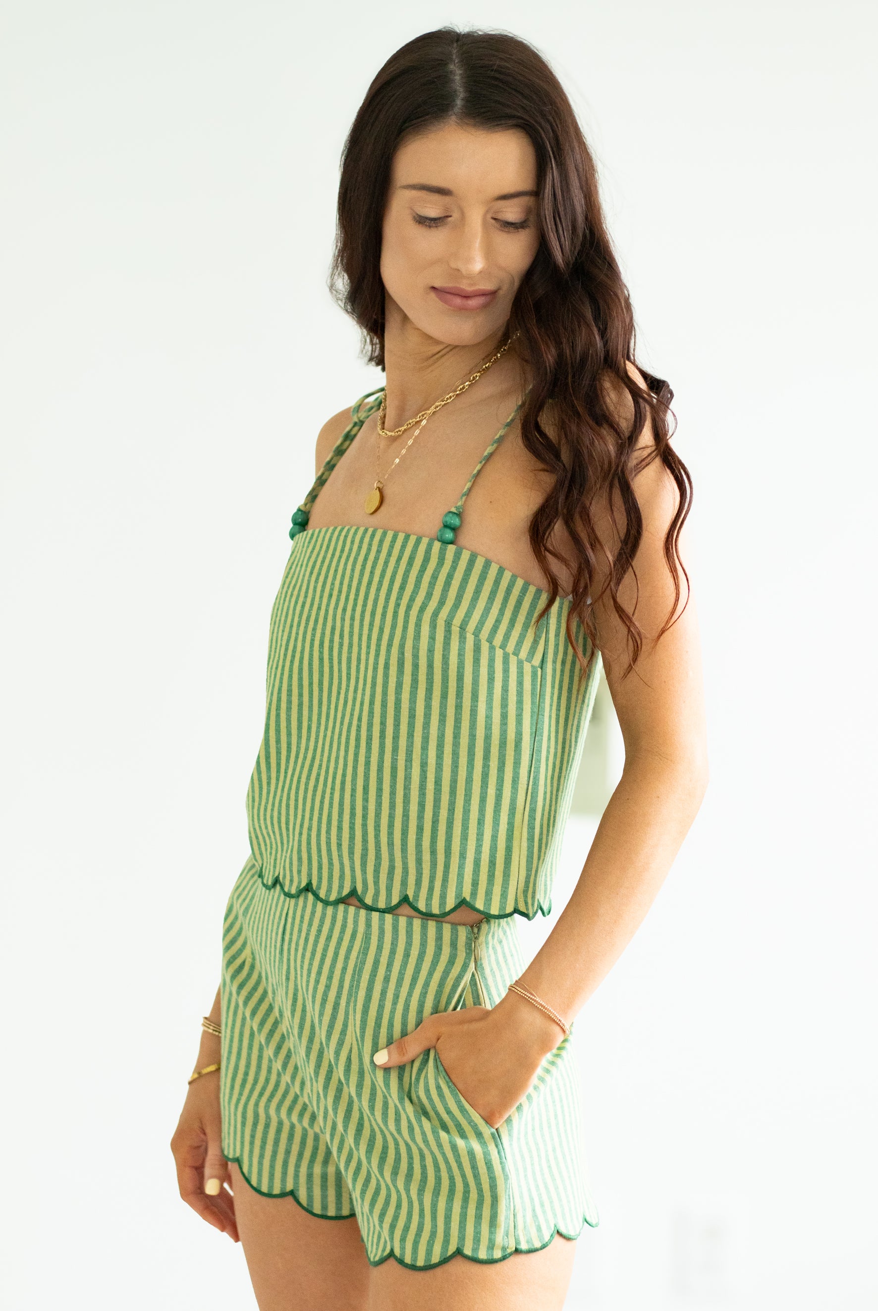 Woman wearing a green striped set on a white background