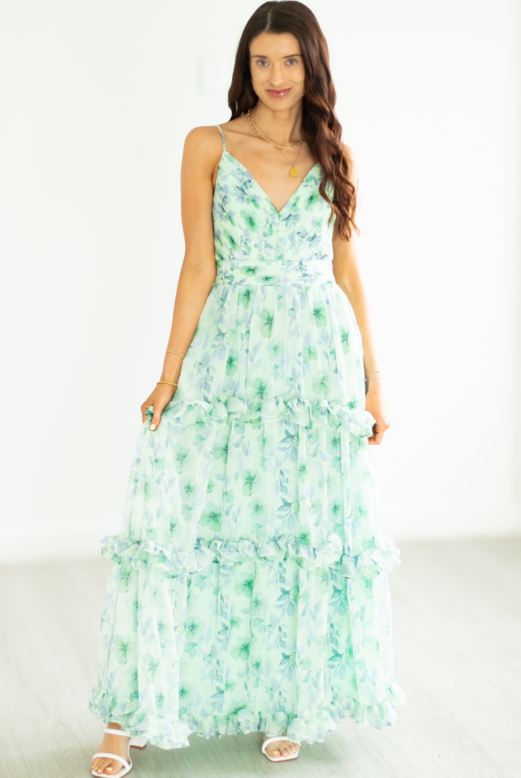 Woman wearing a green floral dress on a white background