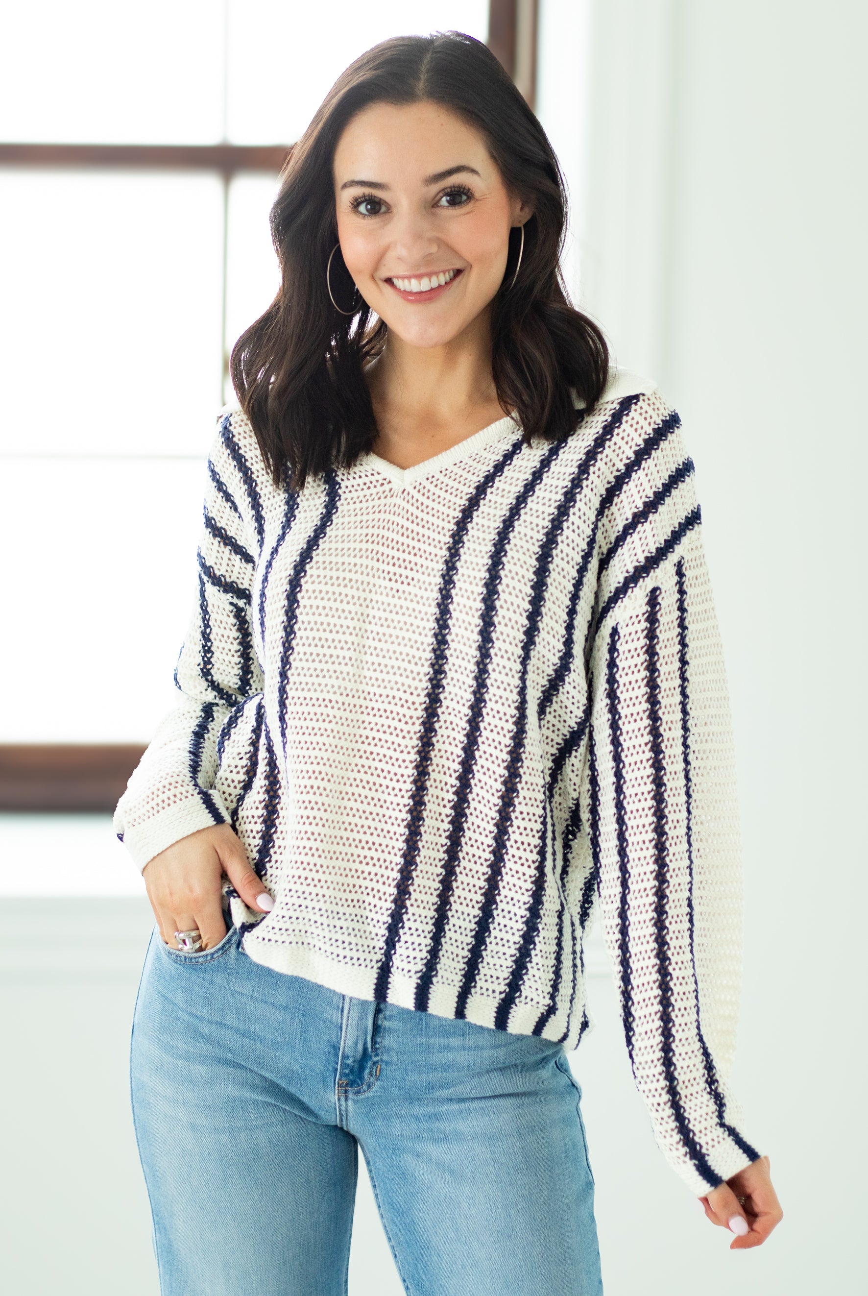 Woman wearing a striped sweater and jeans indoors