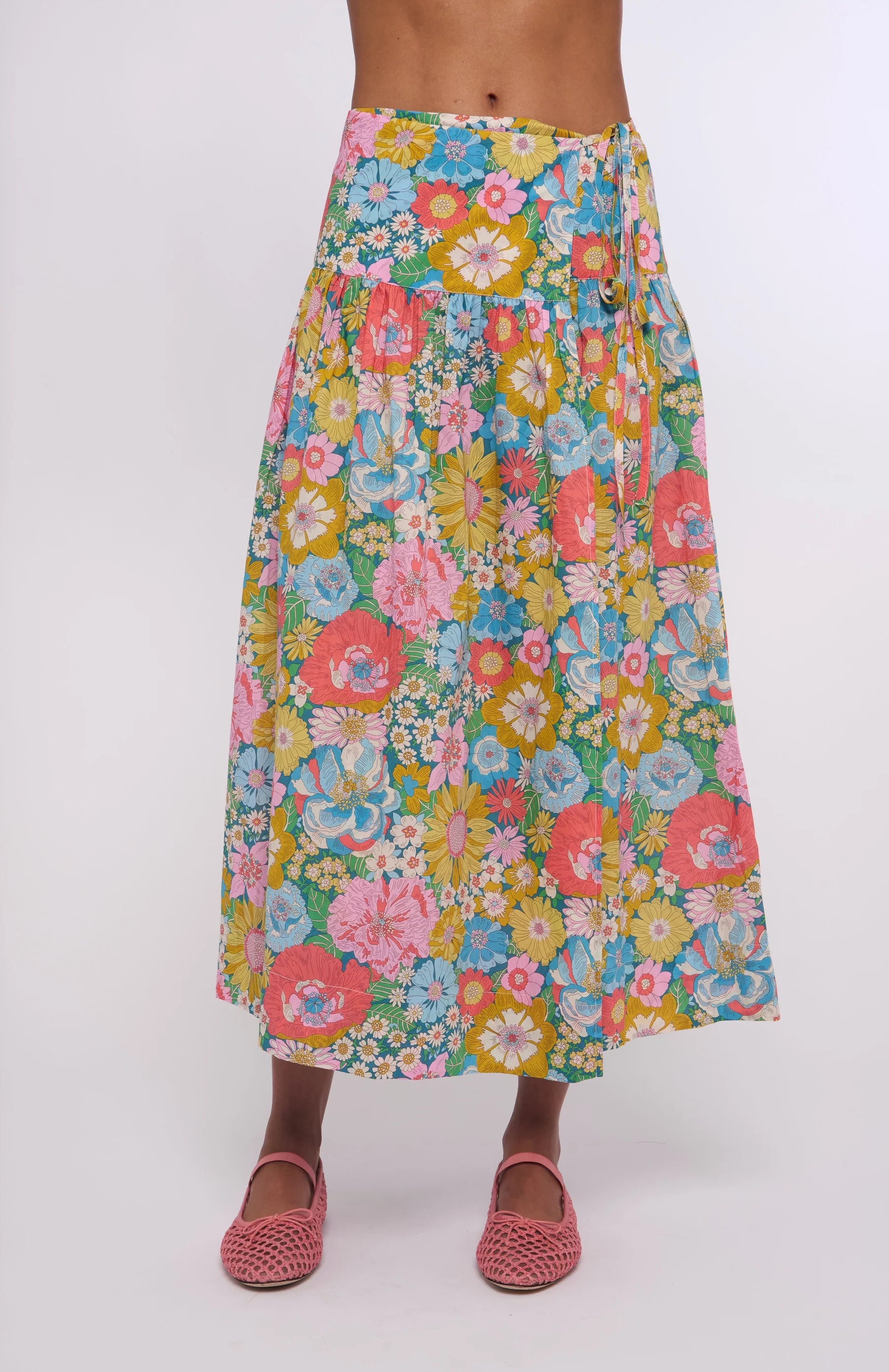 Colorful floral skirt worn by a person on a white background