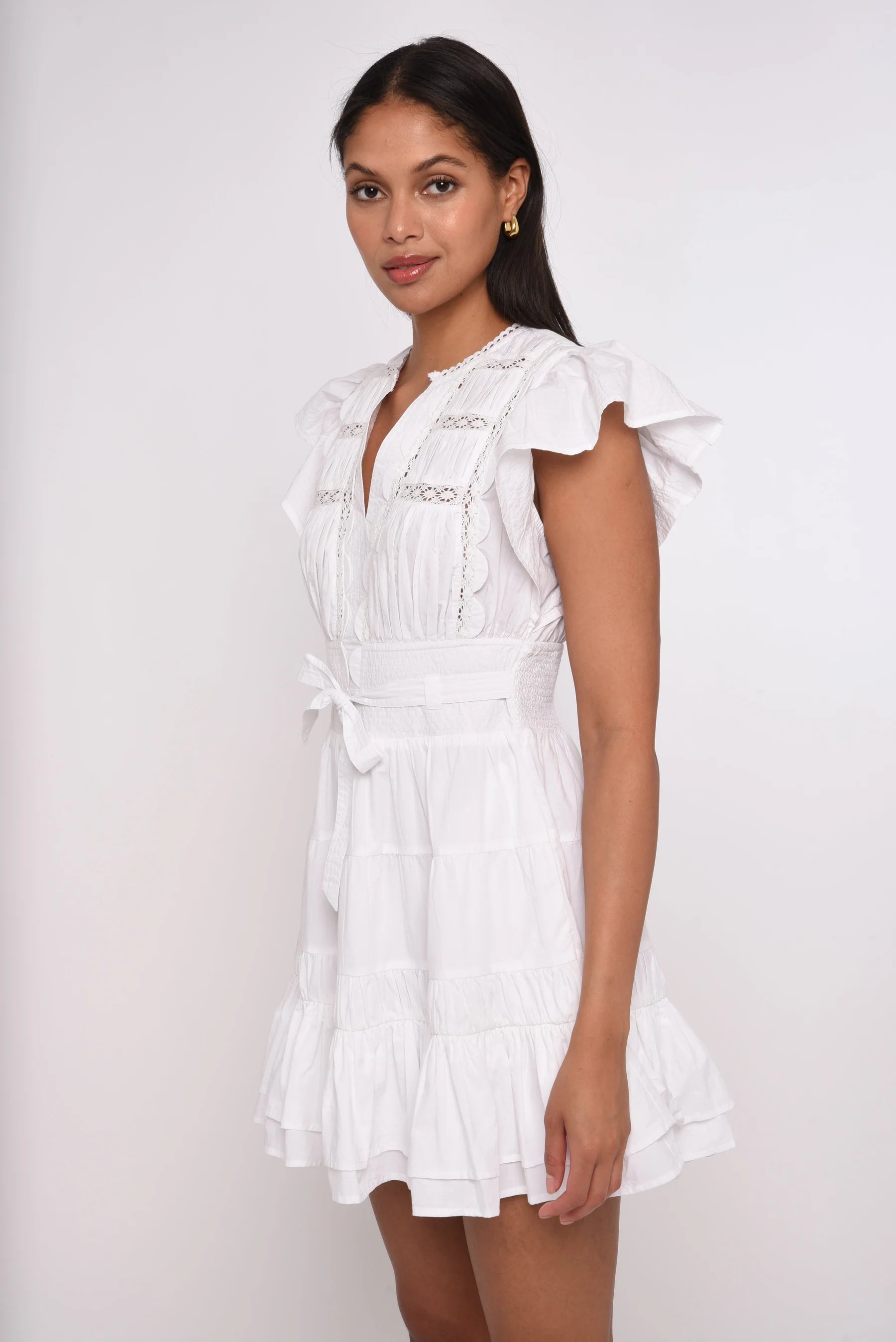 Woman wearing a white dress against a plain background