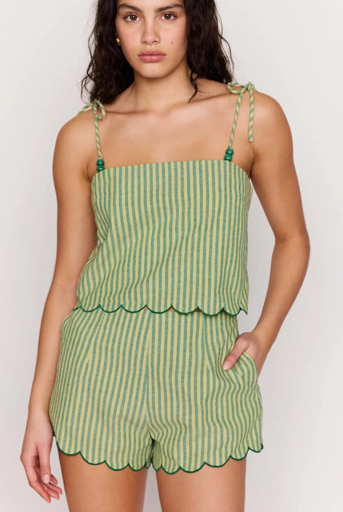 Woman wearing a green striped set on a white background