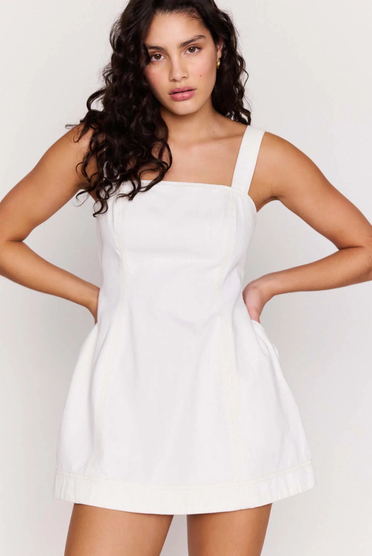 Woman wearing a white dress against a plain background