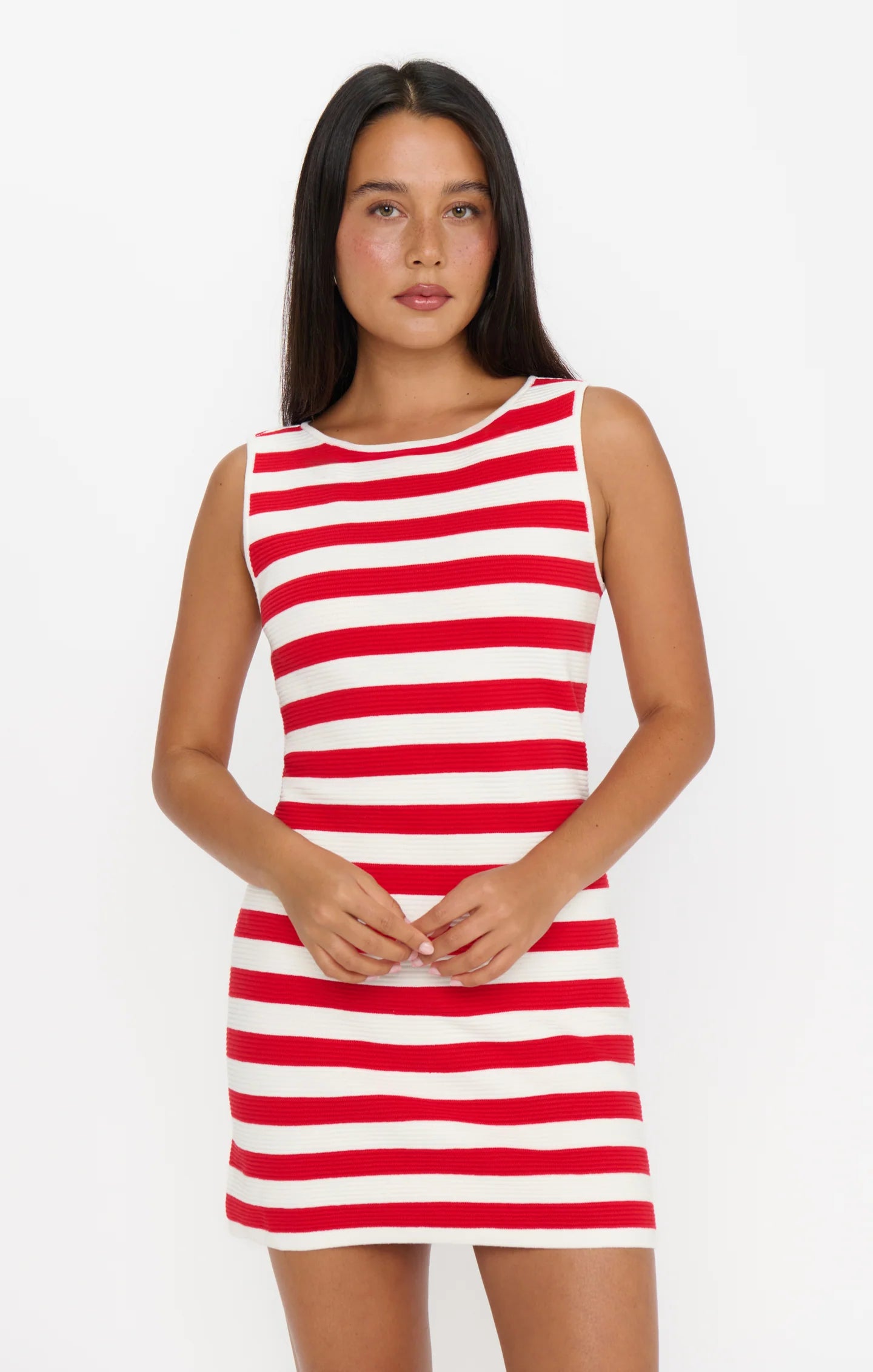 Woman wearing a red and white striped dress on a plain background