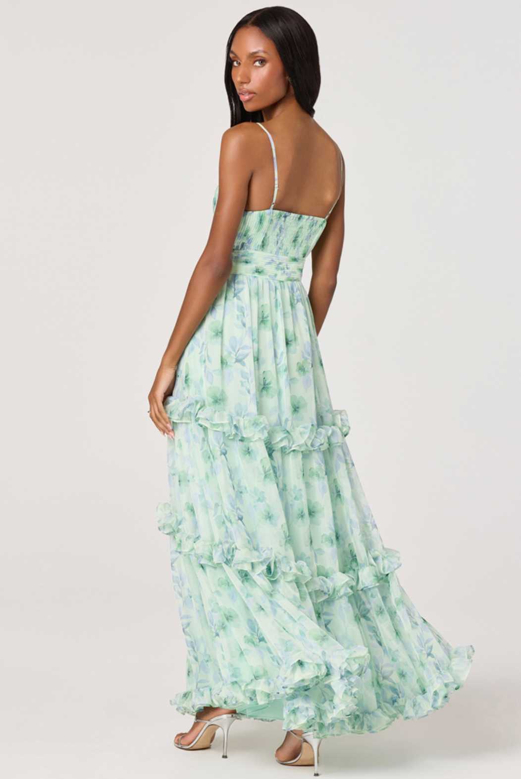 Woman wearing a green floral dress on a white background