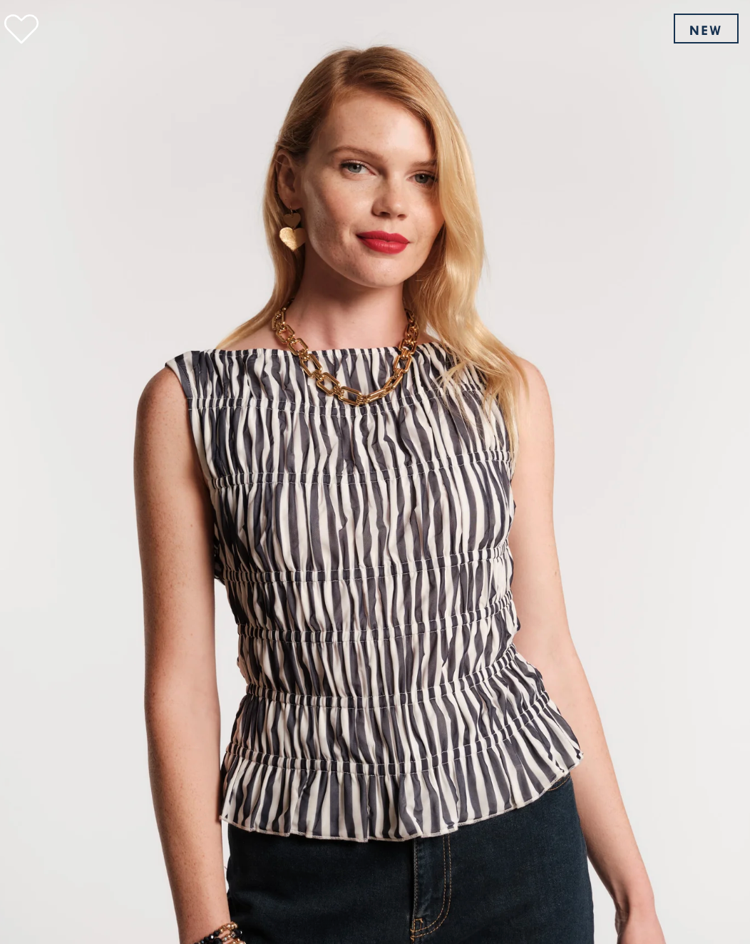 Woman wearing a black and white patterned top on a plain background