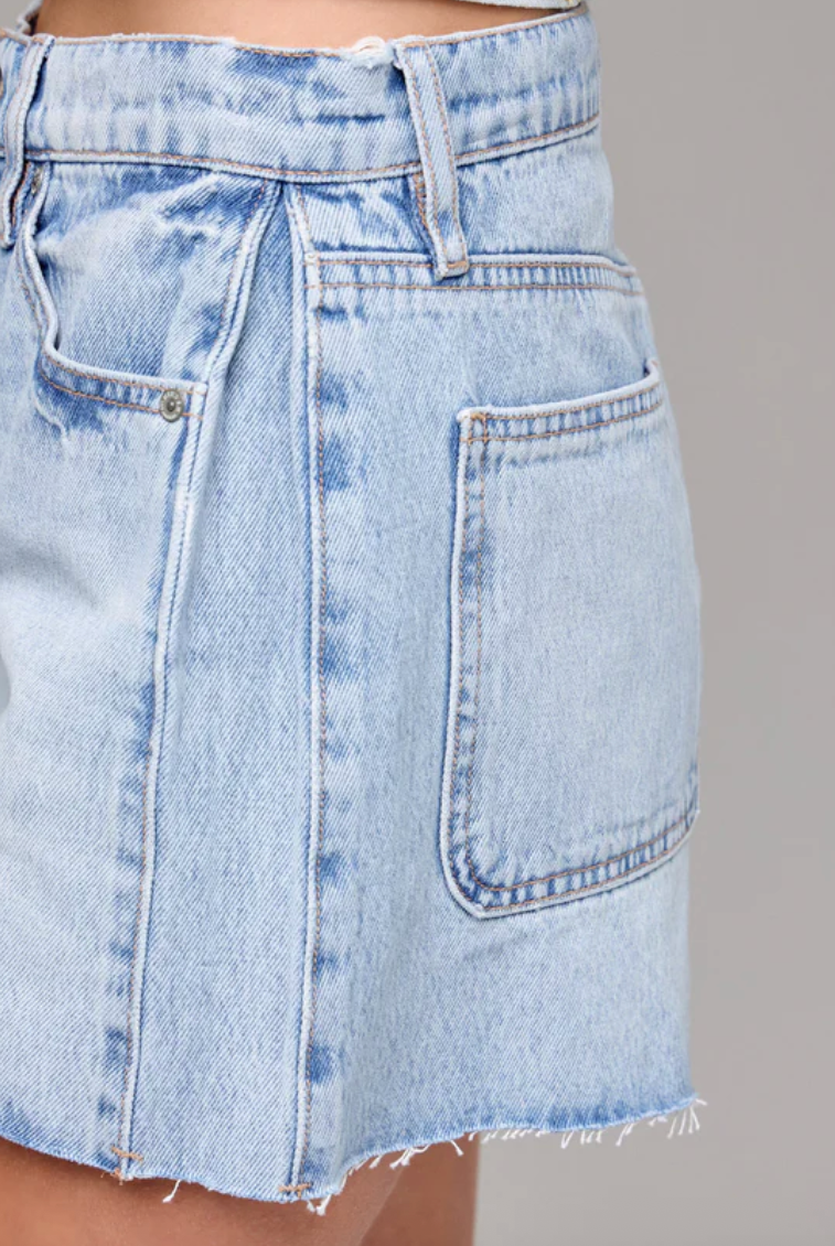Light blue denim skirt on a gray background