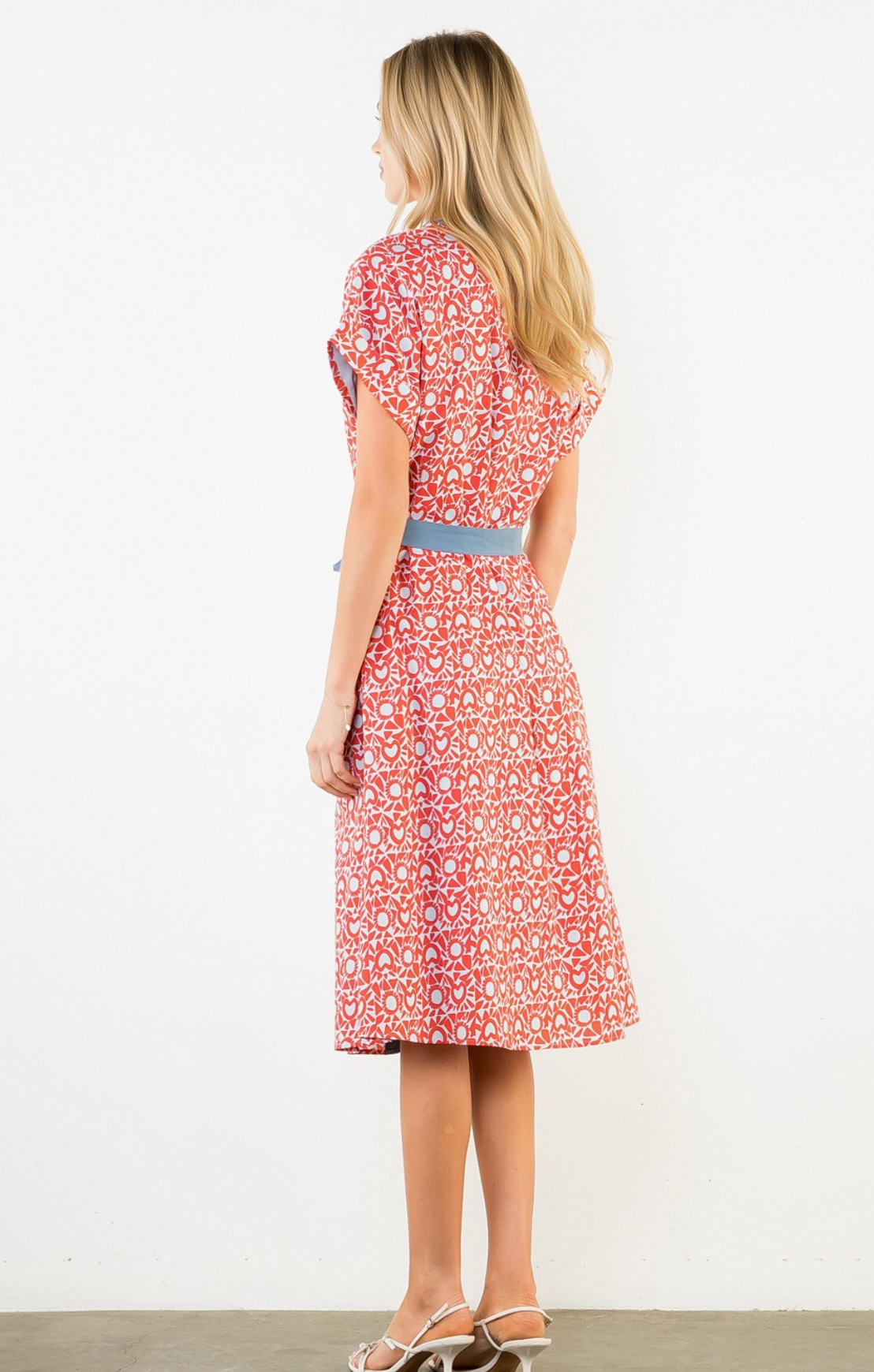Woman wearing a red floral dress with a white background