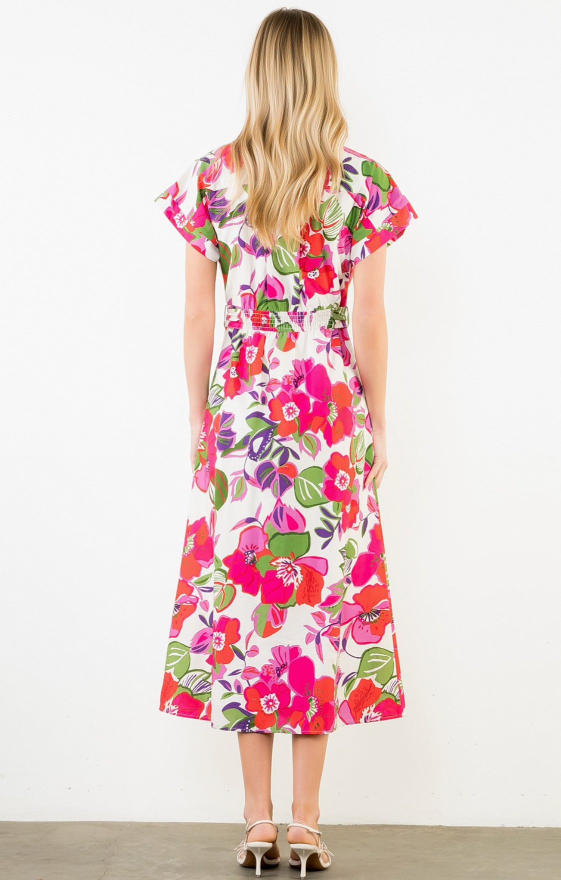 Woman wearing a colorful floral dress on a white background