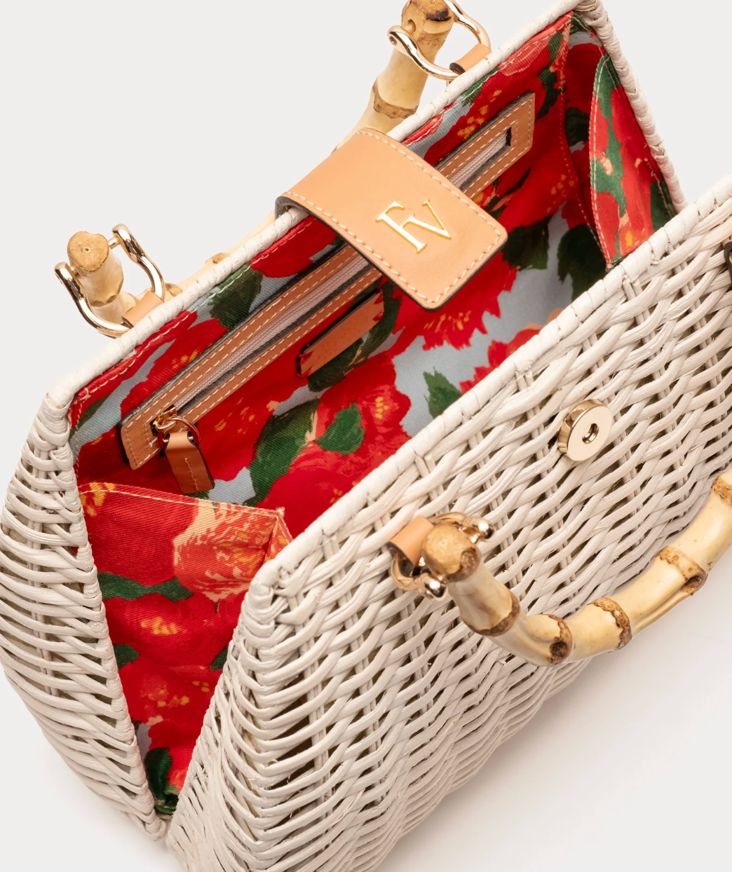 Wicker handbag with floral interior and wooden handle on a white background