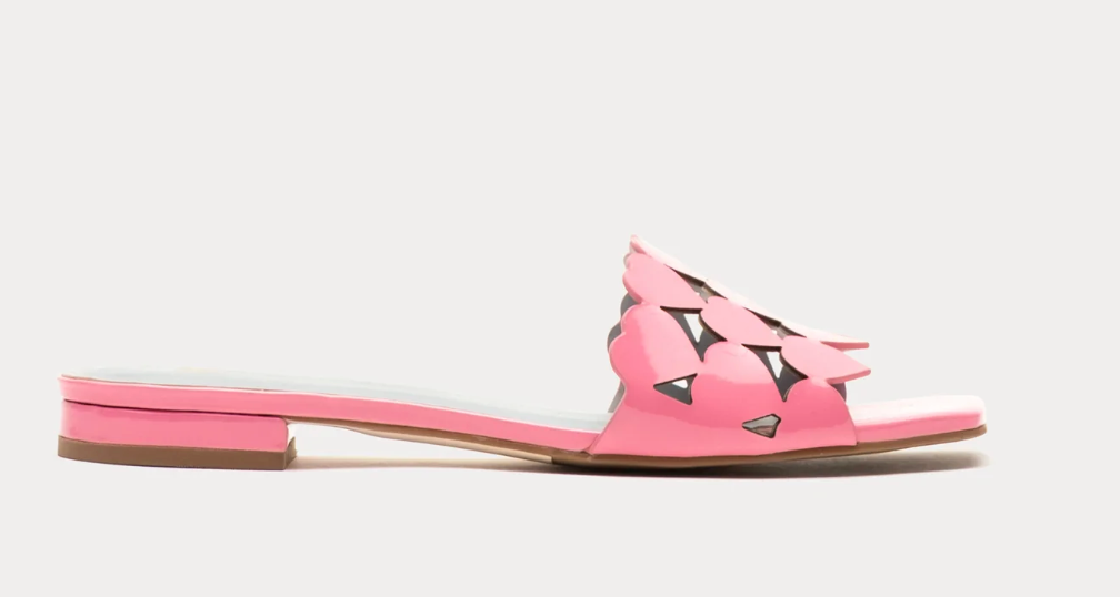 Pink sandal with decorative cutouts on a light gray background