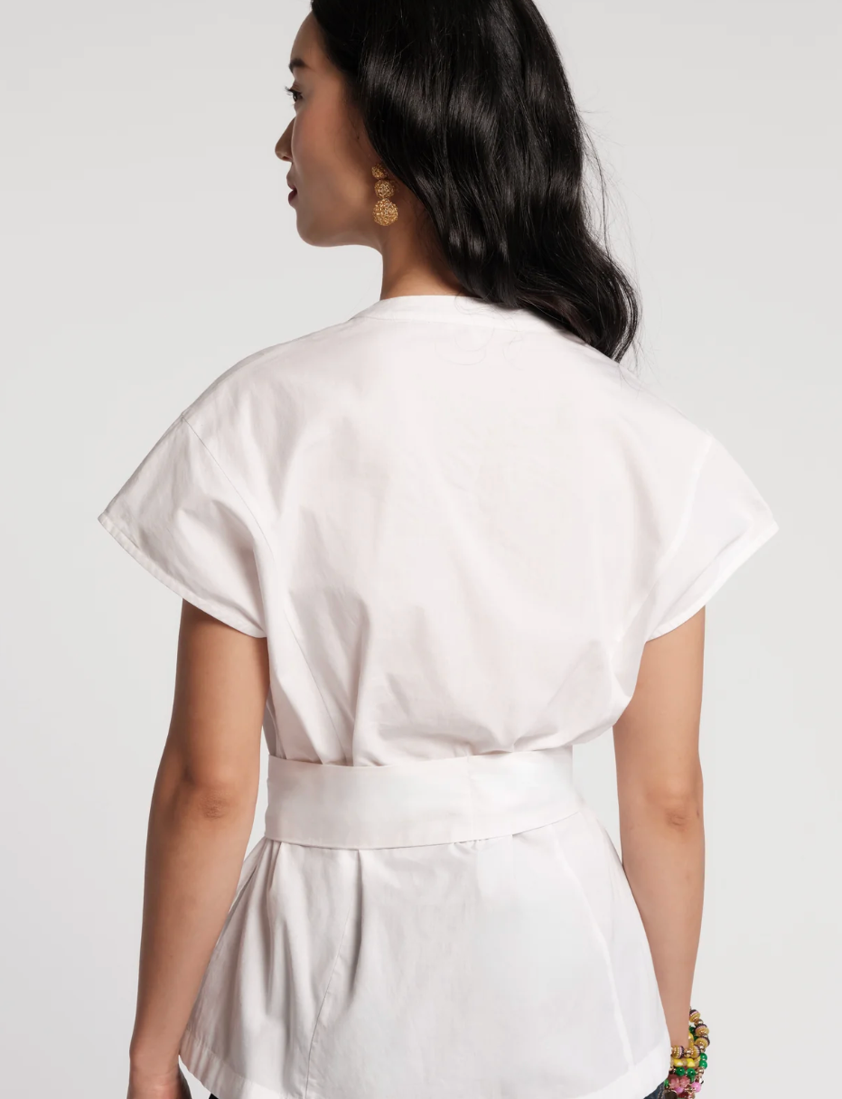 Woman wearing a white dress with a plain background