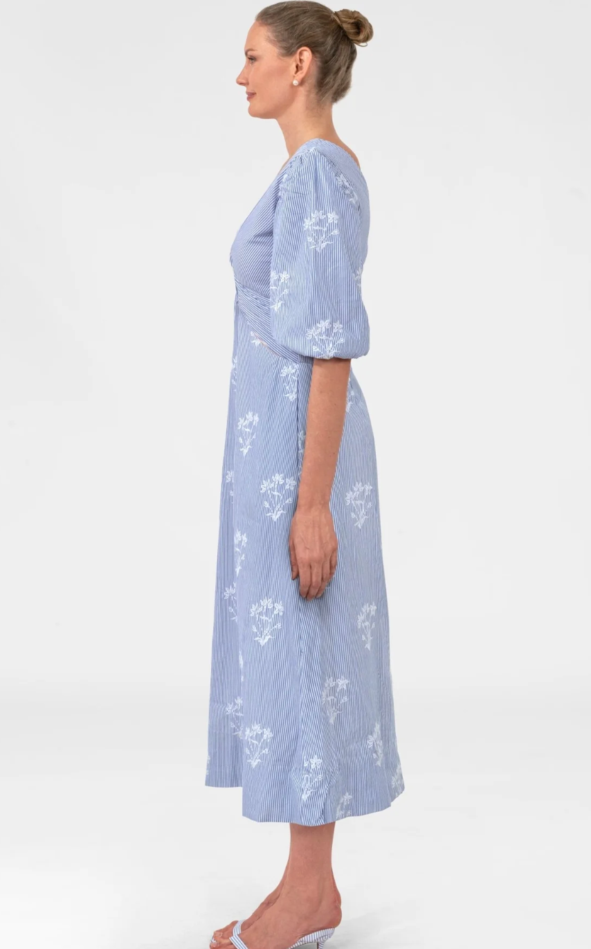 Woman wearing a light blue floral dress on a white background