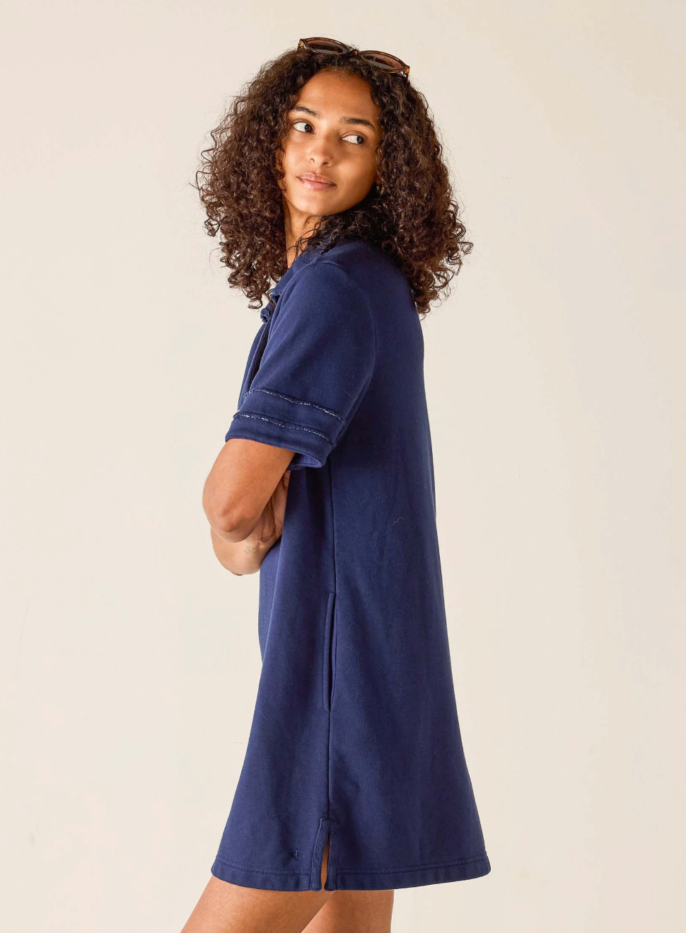 Woman wearing a navy blue dress against a beige background