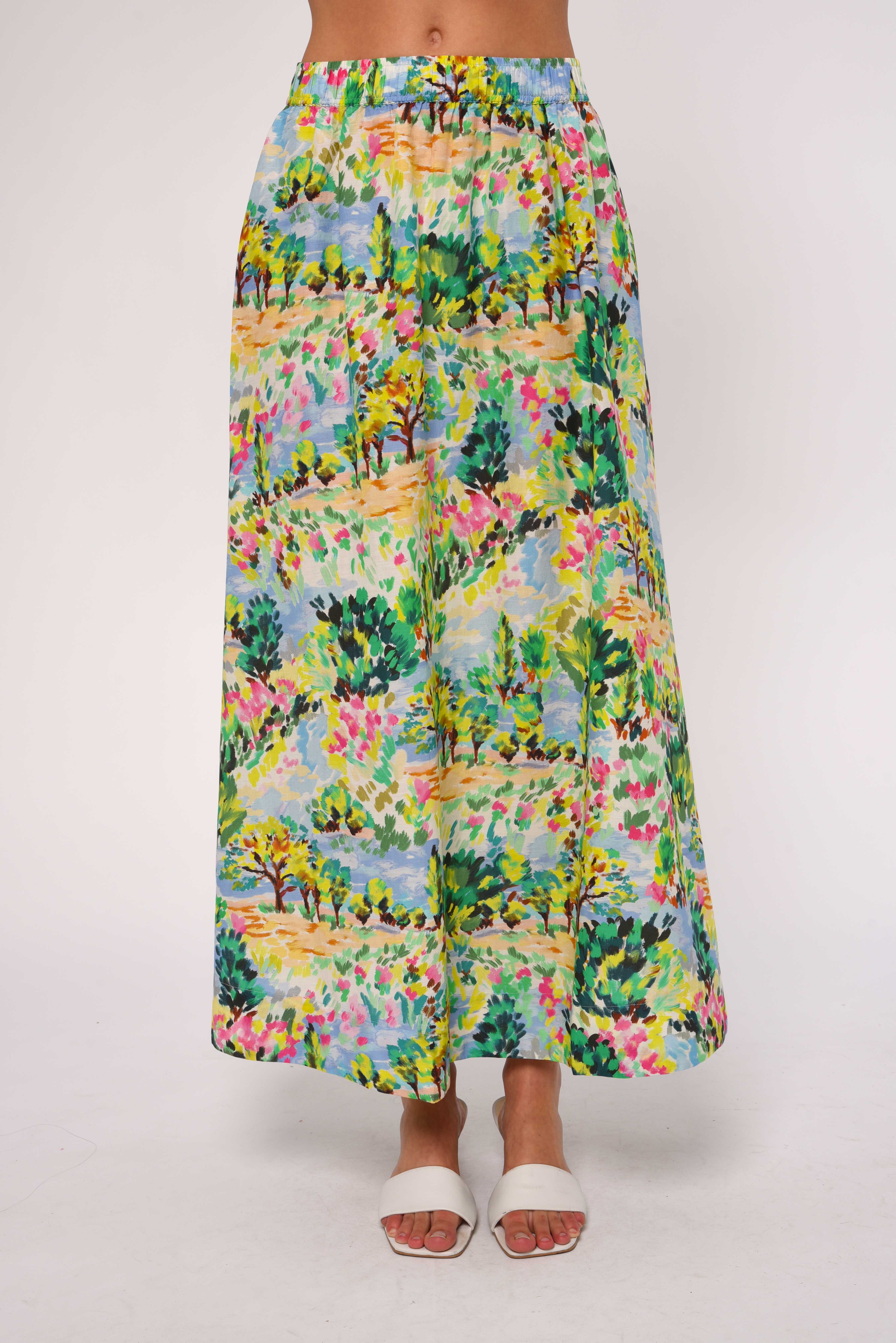Person wearing a colorful floral skirt on a white background