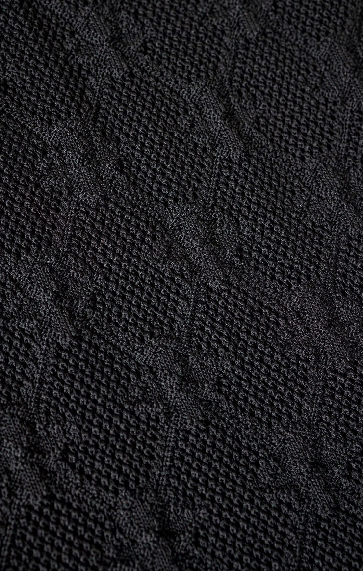 Close-up of a textured black fabric with a diamond pattern