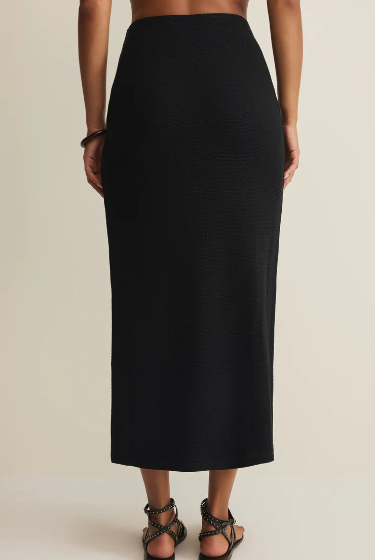 Person wearing a black skirt on a beige background