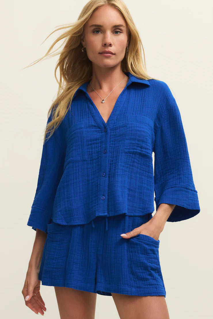 Woman wearing a blue outfit with a plain background