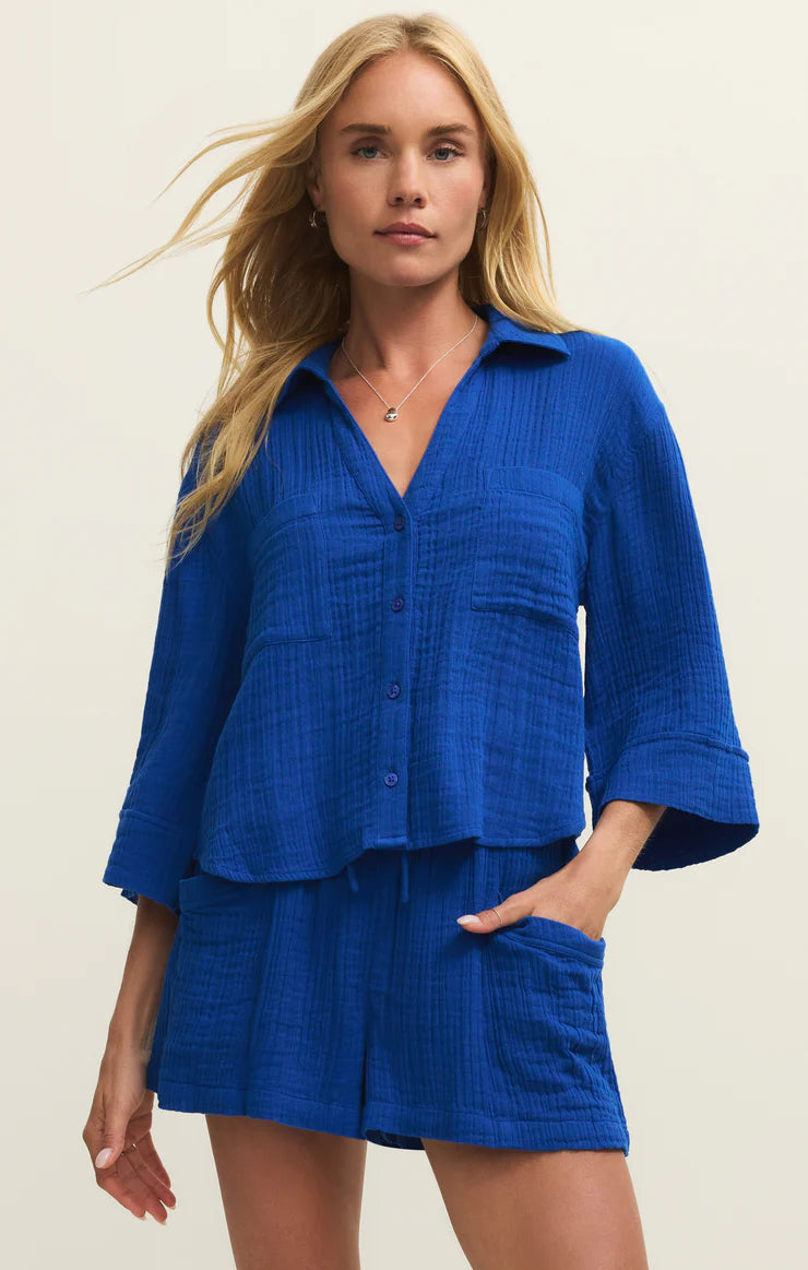 Woman wearing a blue outfit with a plain background