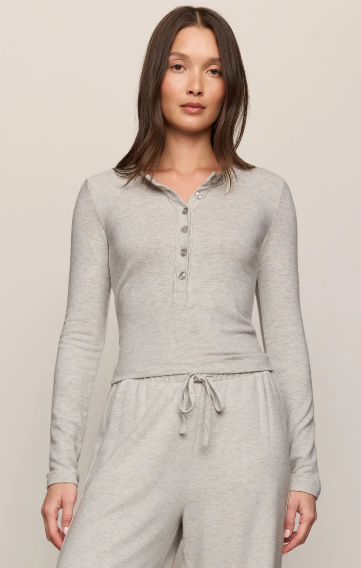 Model wearing a heather gray long sleeve henley top with button-front detail.