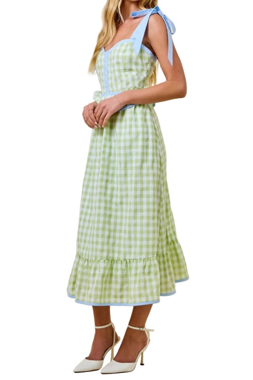 Woman wearing a green checkered dress with blue accents on a beige background