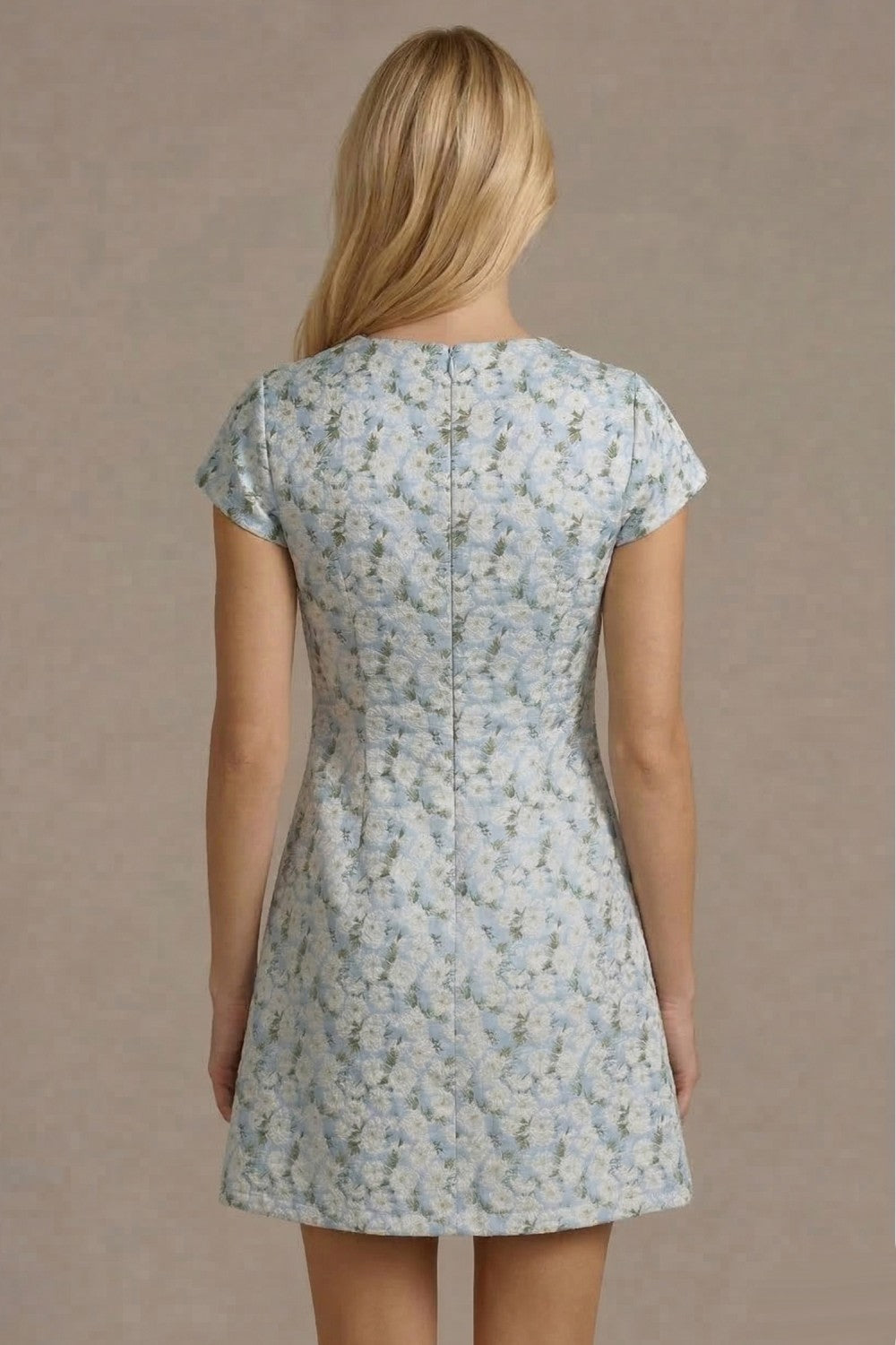 Woman wearing a floral dress against a plain background