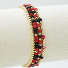 Beaded bracelet with red and black beads on a white surface