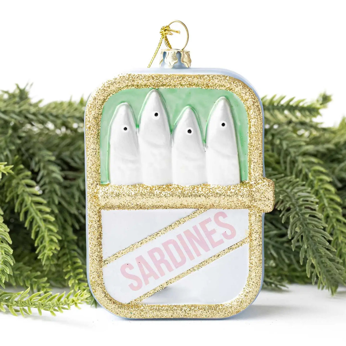 Decorative ornament shaped like a can of sardines with green background and gold glitter.