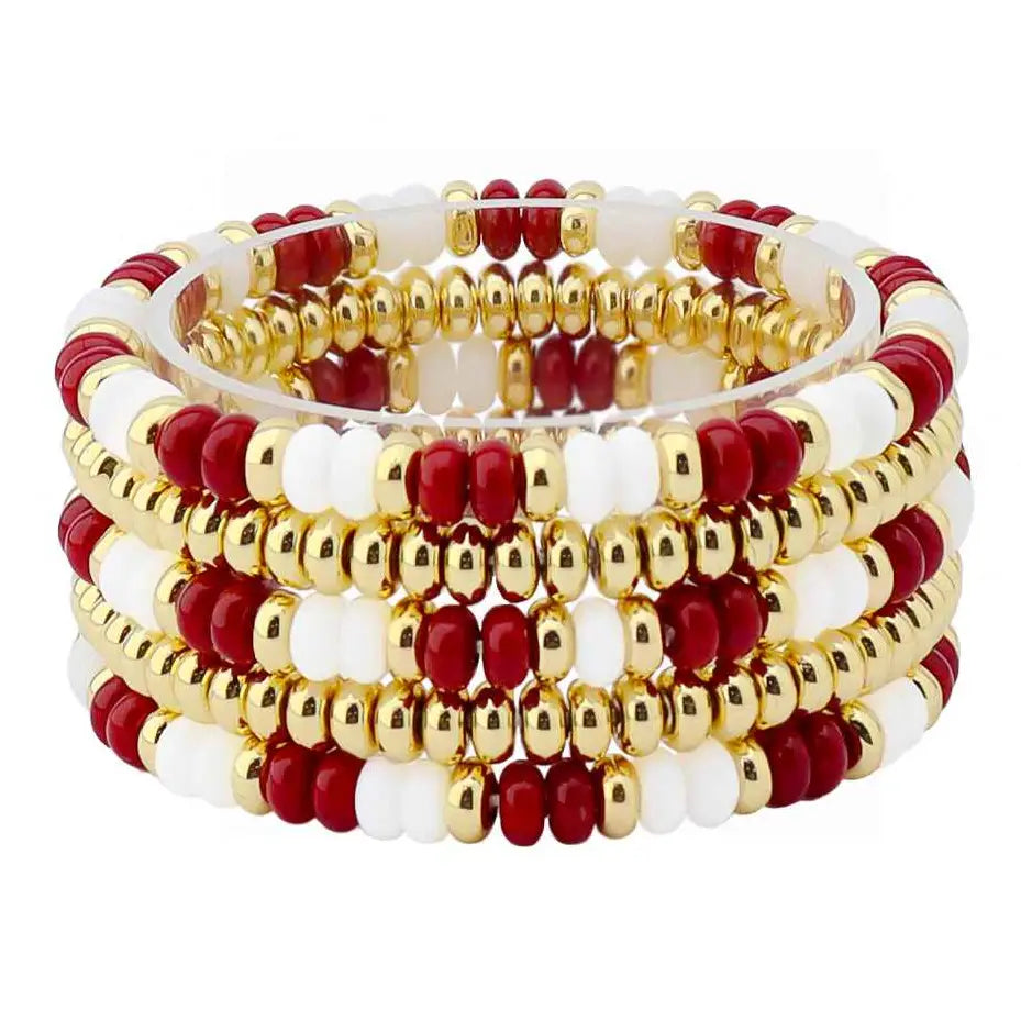 A stack of beaded stretch bracelets featuring alternating red and white beads with shiny gold metallic spacer beads, displayed on a clean white background.
