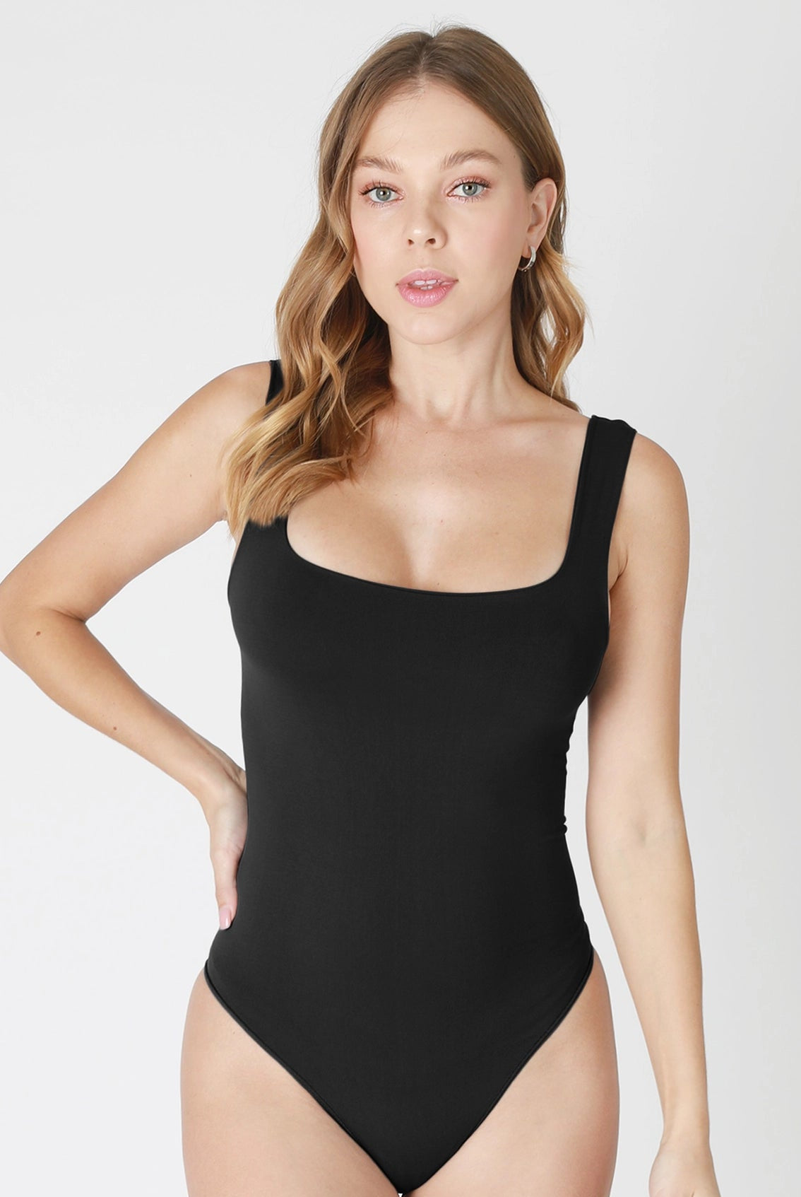 Woman wearing a black swimsuit against a white background