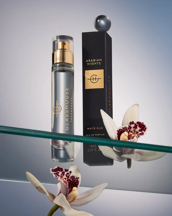 Perfume bottle and packaging with flowers on a reflective surface