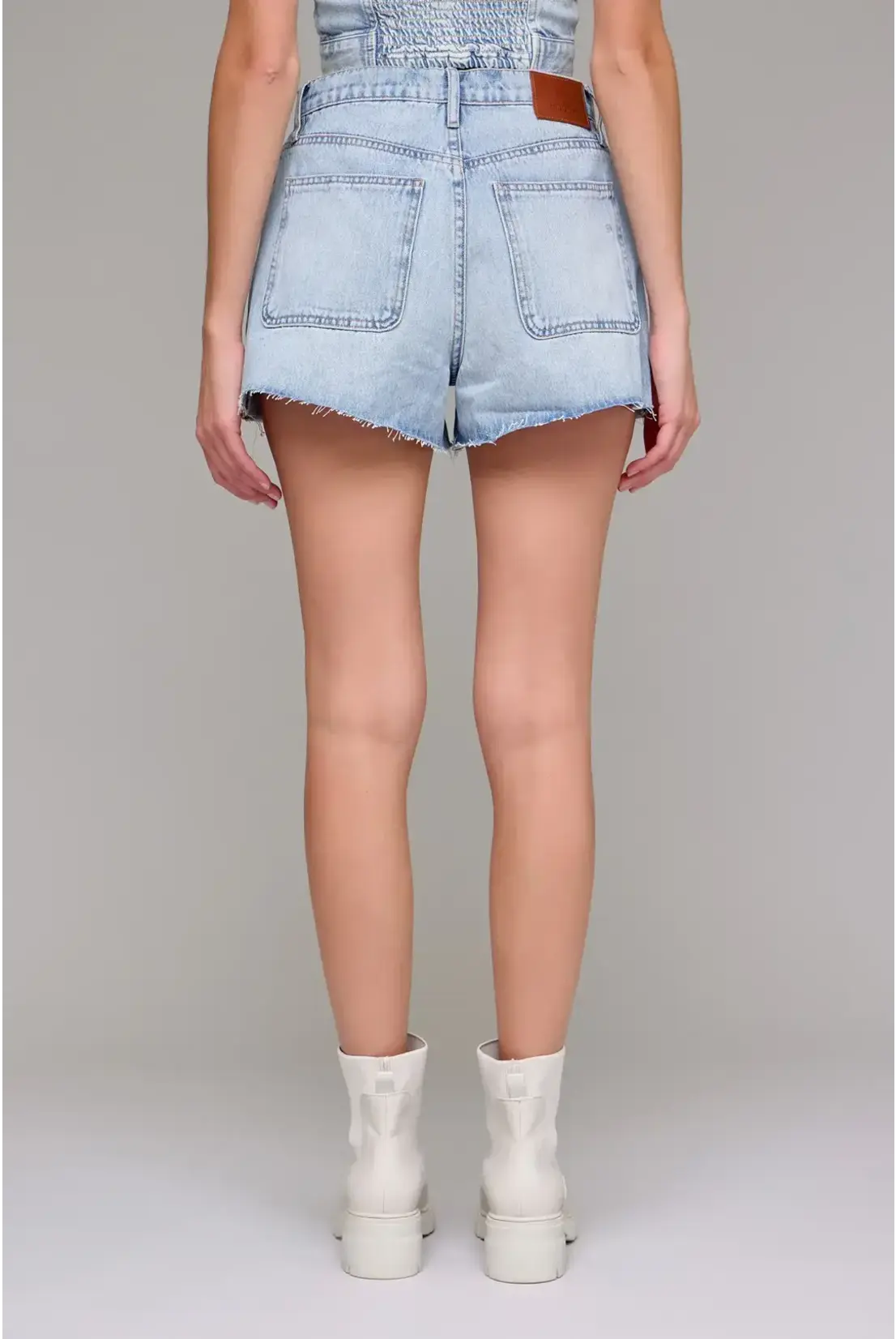 Light blue denim shorts worn by a person on a plain background