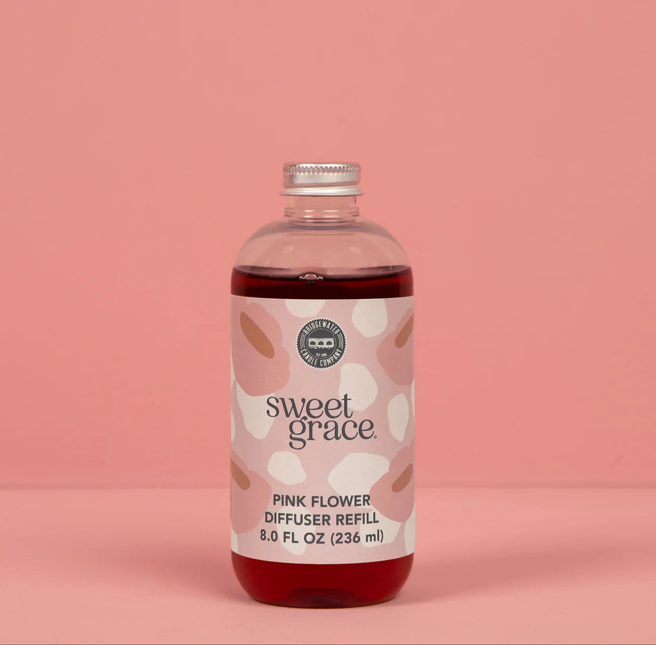 Sweet Grace pink flower diffuser refill bottle on a pink background