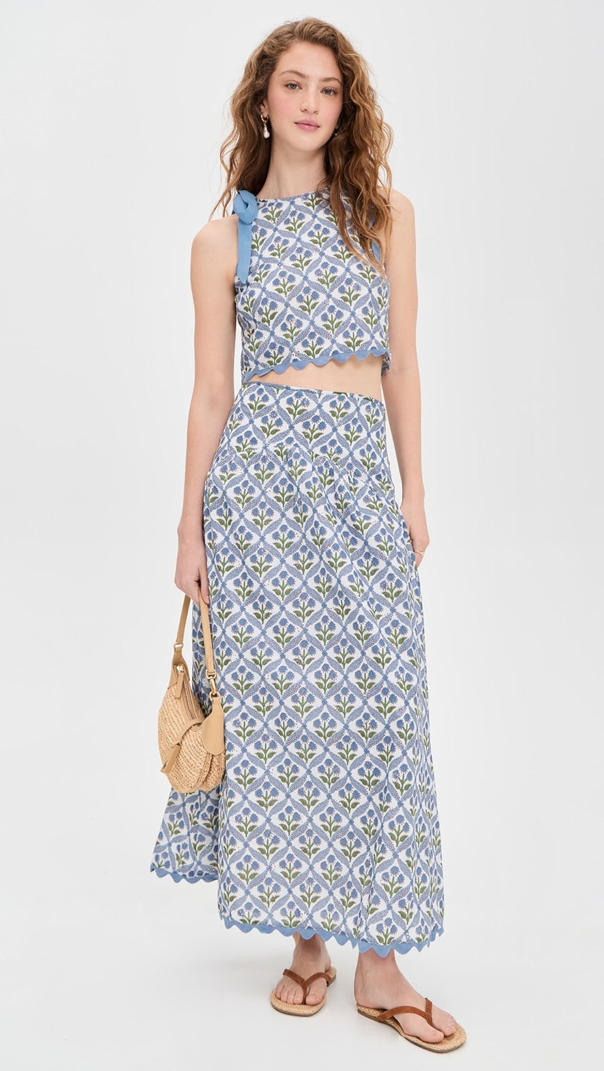 Woman wearing a blue patterned dress with a white background