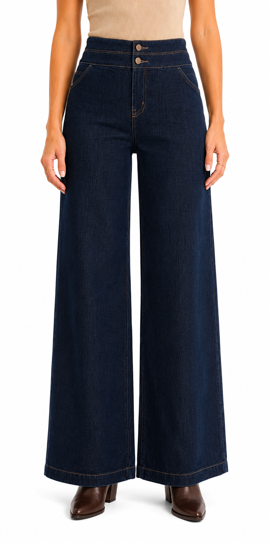 A model wearing dark navy blue wide-leg denim pants with a high waist and double button closure, paired with brown ankle boots against a plain white background.