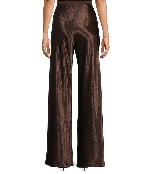 A pair of high-waisted, wide-leg trousers in a shiny, metallic dark brown satin fabric, shown on a model from the back against a plain white background.