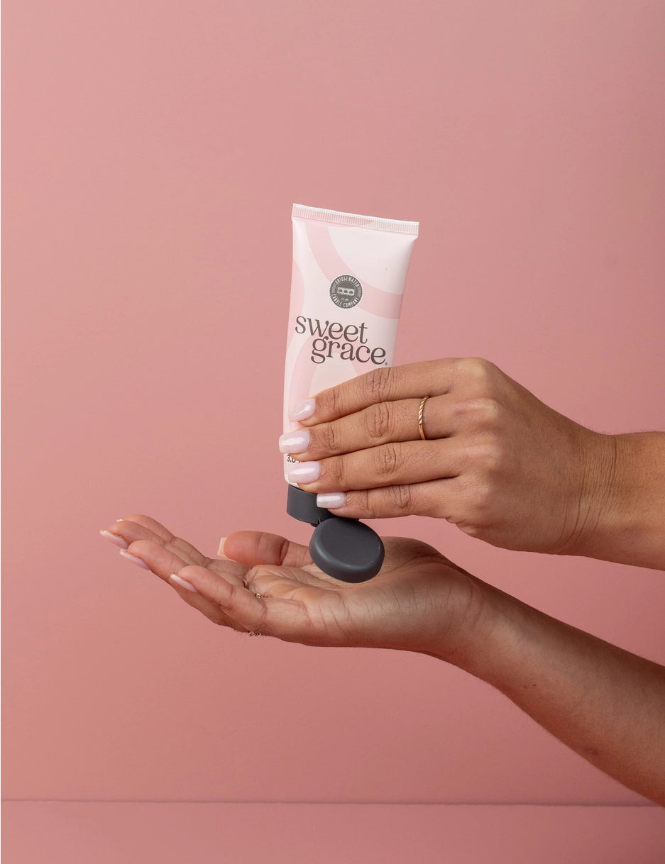 Person holding a 'sweet grace' skincare product against a pink background