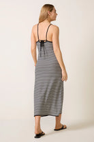 Woman wearing a black and white striped dress on a plain background