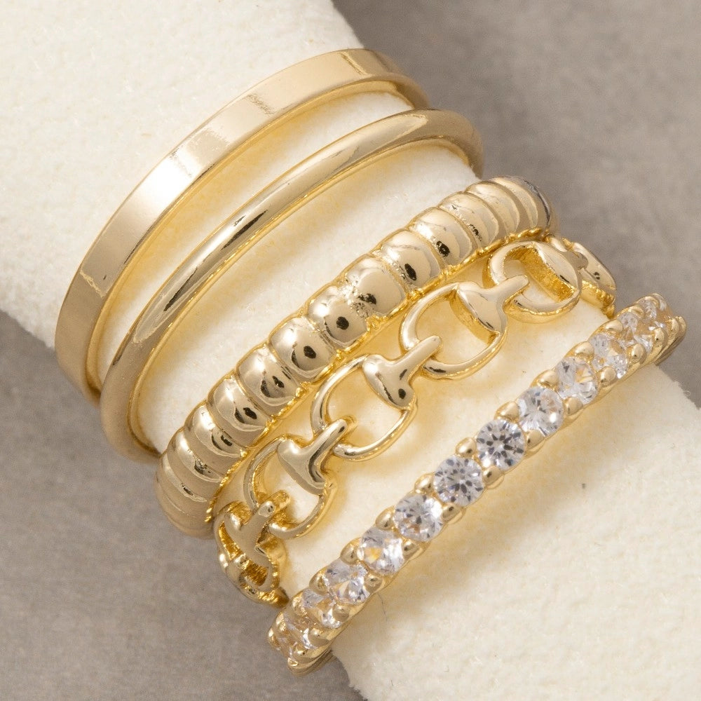 Set of gold rings with different designs on a soft surface