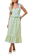 Woman wearing a green checkered dress with blue accents on a beige background