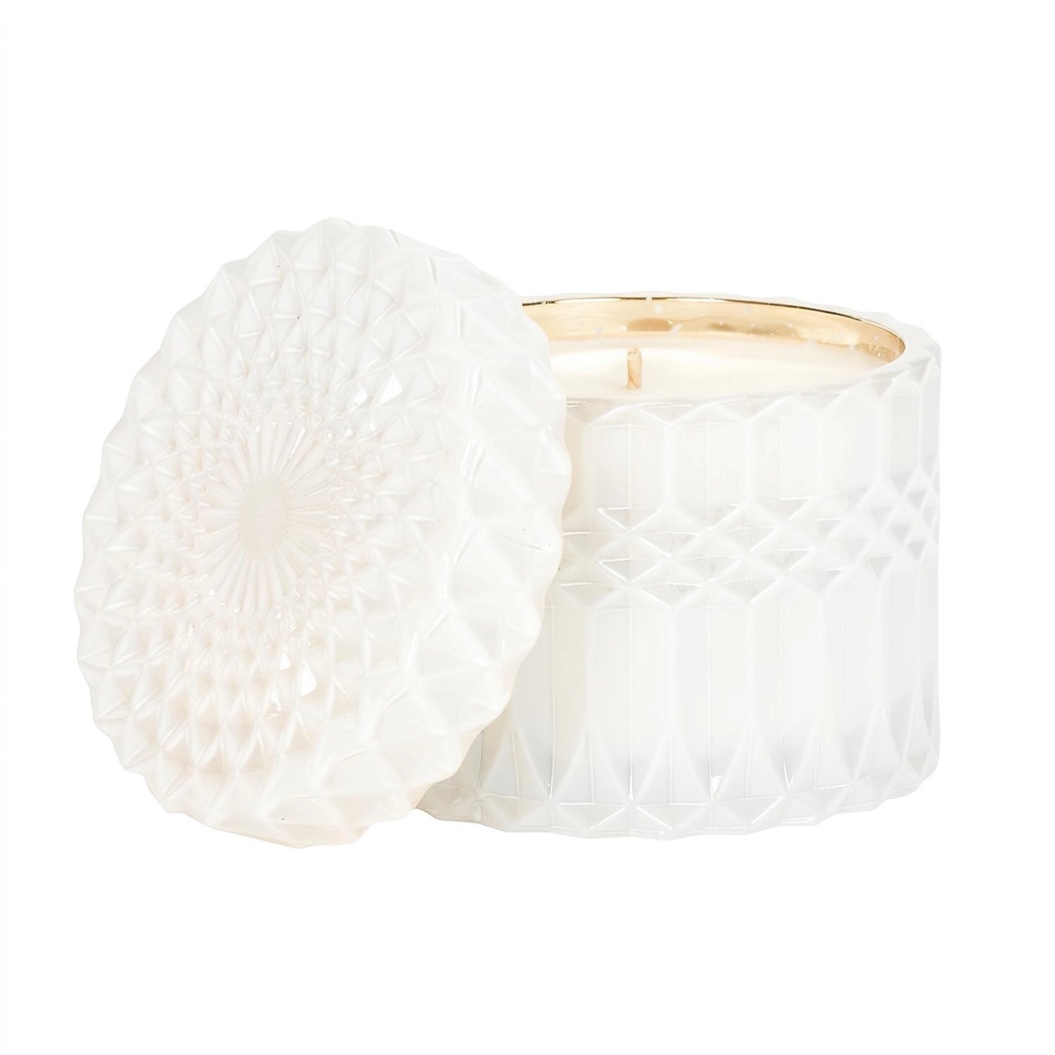A white textured glass jar candle with its lid leaning against it, set against a clean white background.