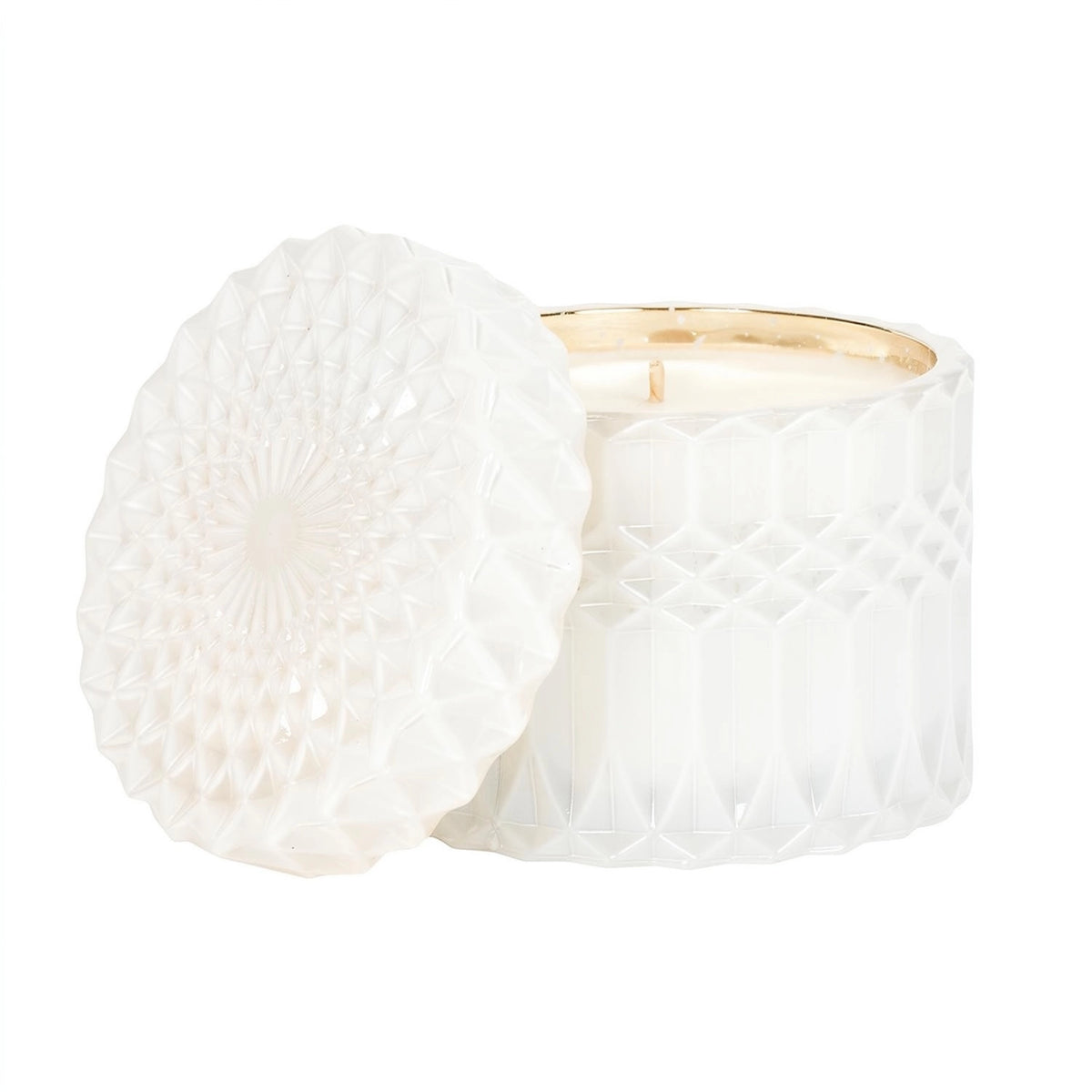 A white textured glass jar candle with its lid leaning against it, set against a clean white background.